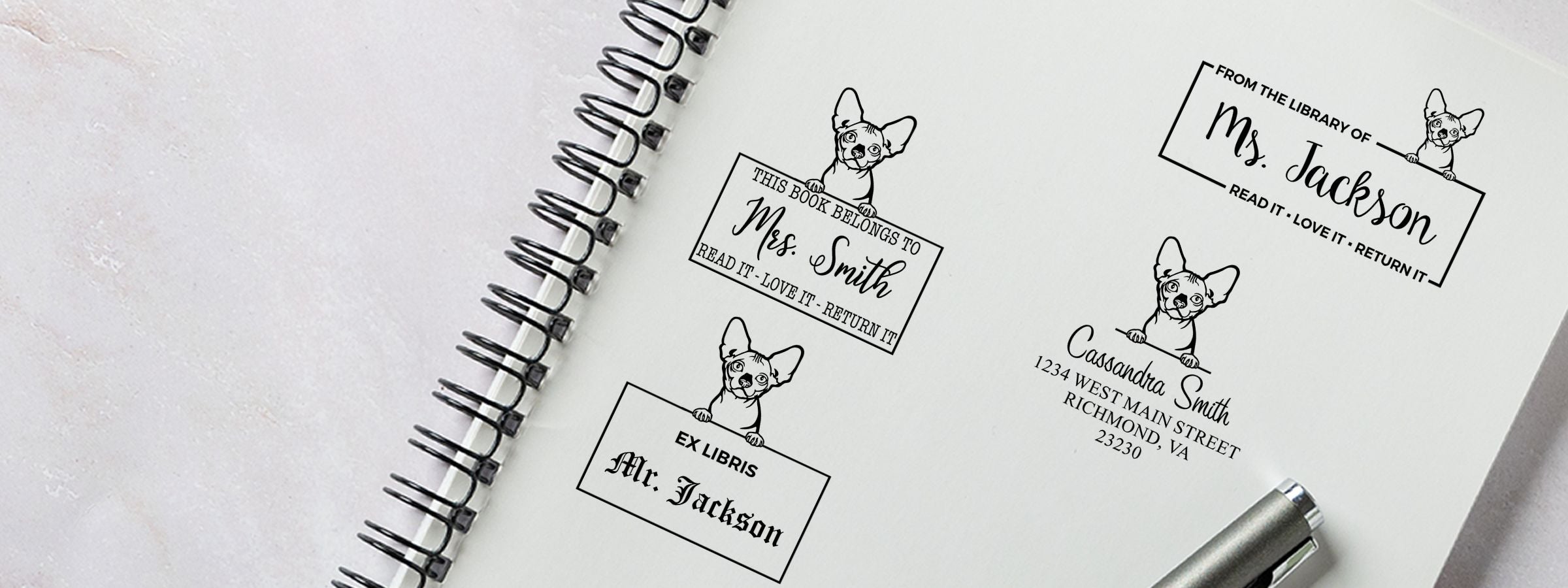 Spiral-bound page of custom bookplate designs with a dog illustration and names, plus a pen; Bambino Cat Stamps and Custom Seals.