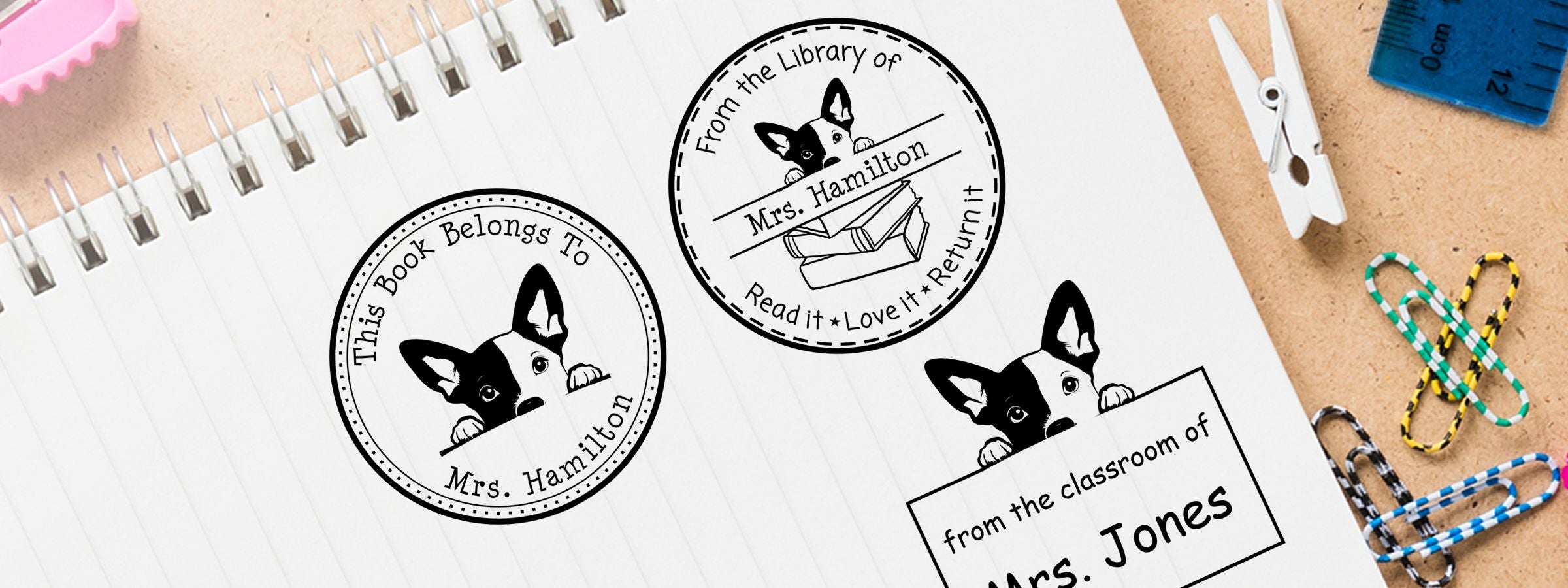 Basenji Dog Stamps and Custom Seals stationery mockup with three dog bookplate stamps on a spiral notebook, surrounded by craft supplies.