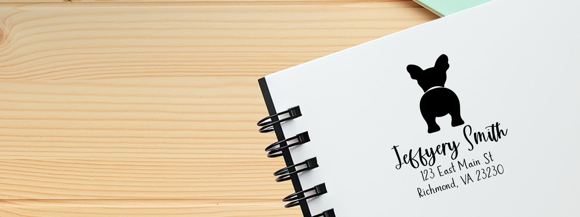 Spiral-bound notebook on wood table, white cover with black dog silhouette, Jeffery Smith, Richmond, VA, Bulldog Dog Stamps and Custom Seals