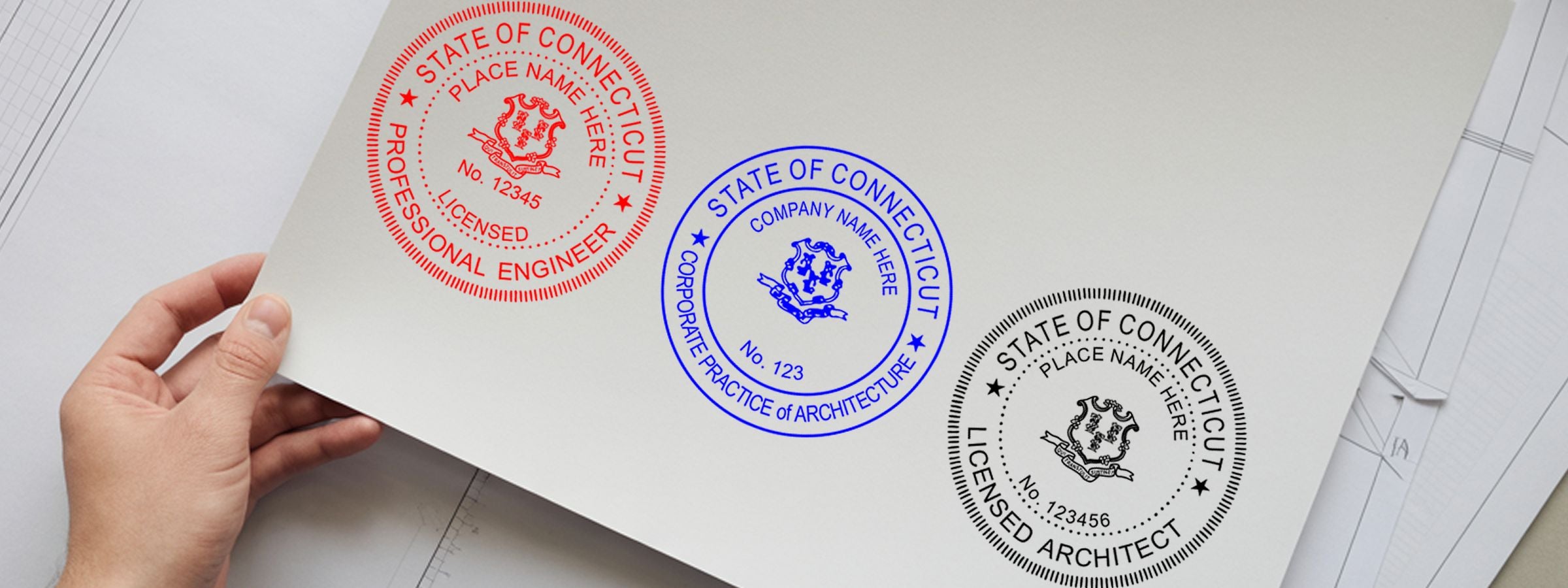 Connecticut Professional Seals and Stamps: hand holding three Connecticut seals for engineer, architecture corporation, and architect over blueprints.
