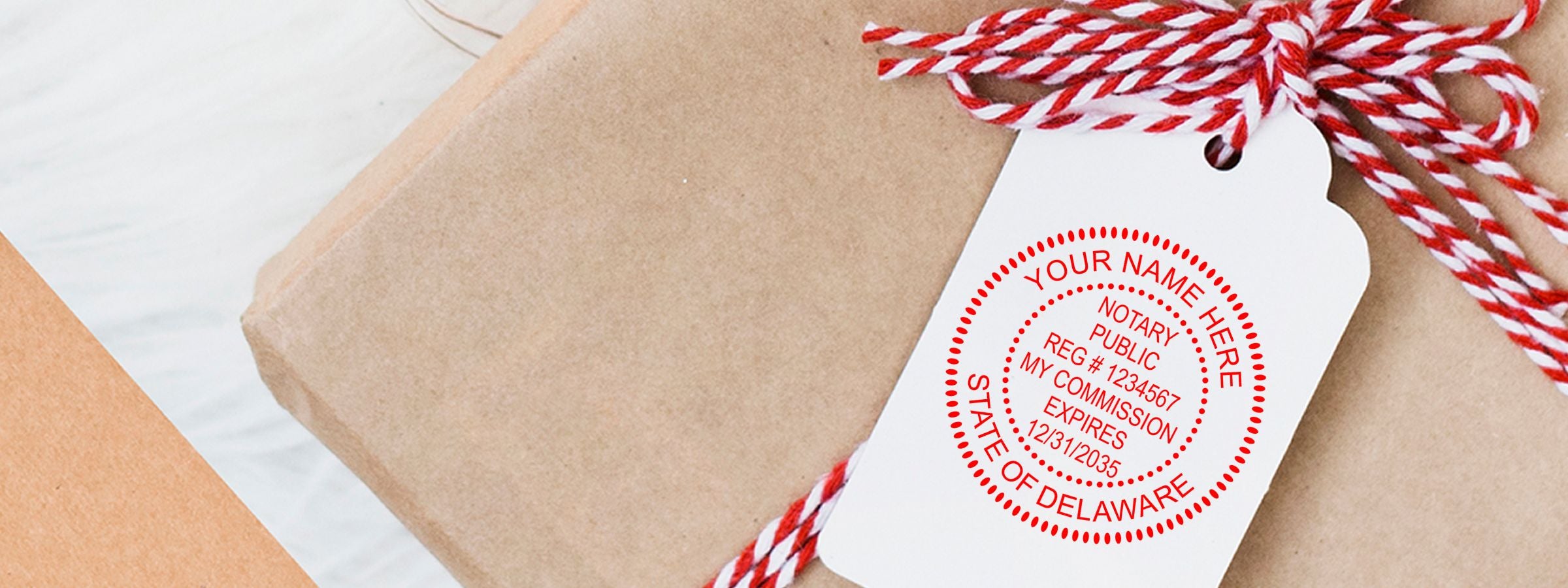 Close-up of a wrapped gift with a white tag and red-and-white string, featuring a red Delaware notary seal from Delaware Notary Supplies, Stamps and Seals.