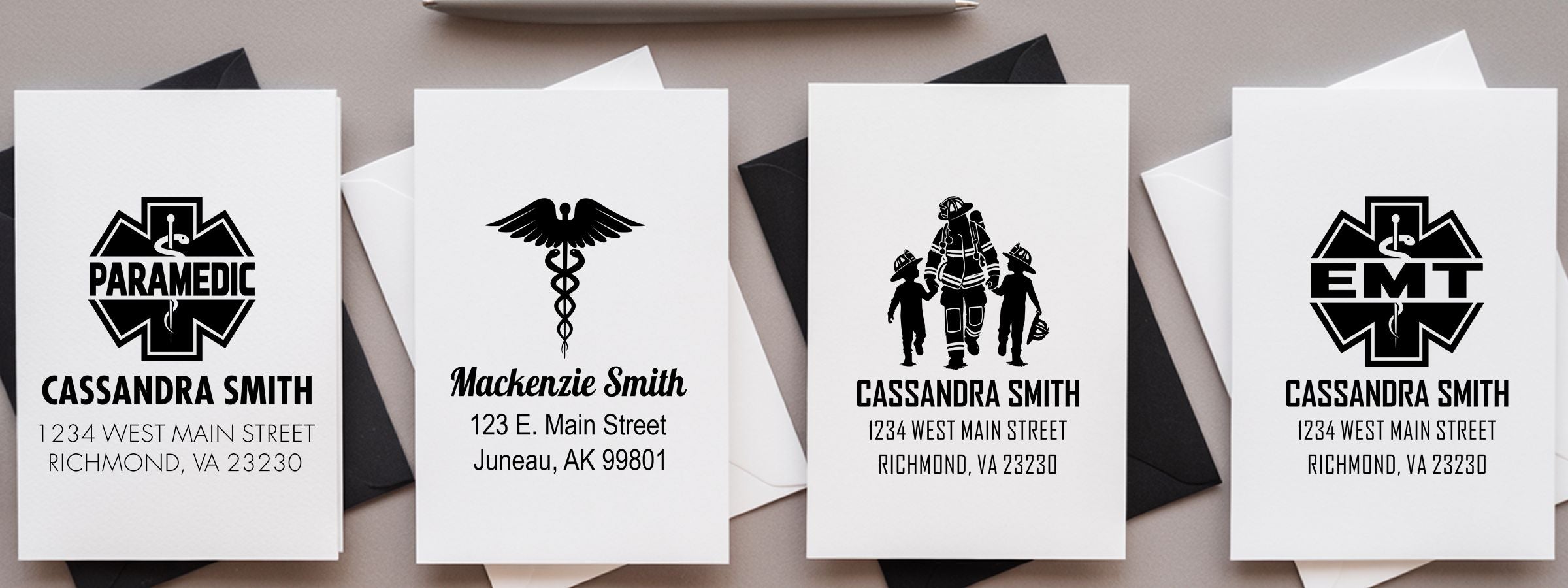 Four white folded memorial cards with Fire and EMS Designer Stamps, showing paramedic, caduceus, firefighter, and EMT emblems.