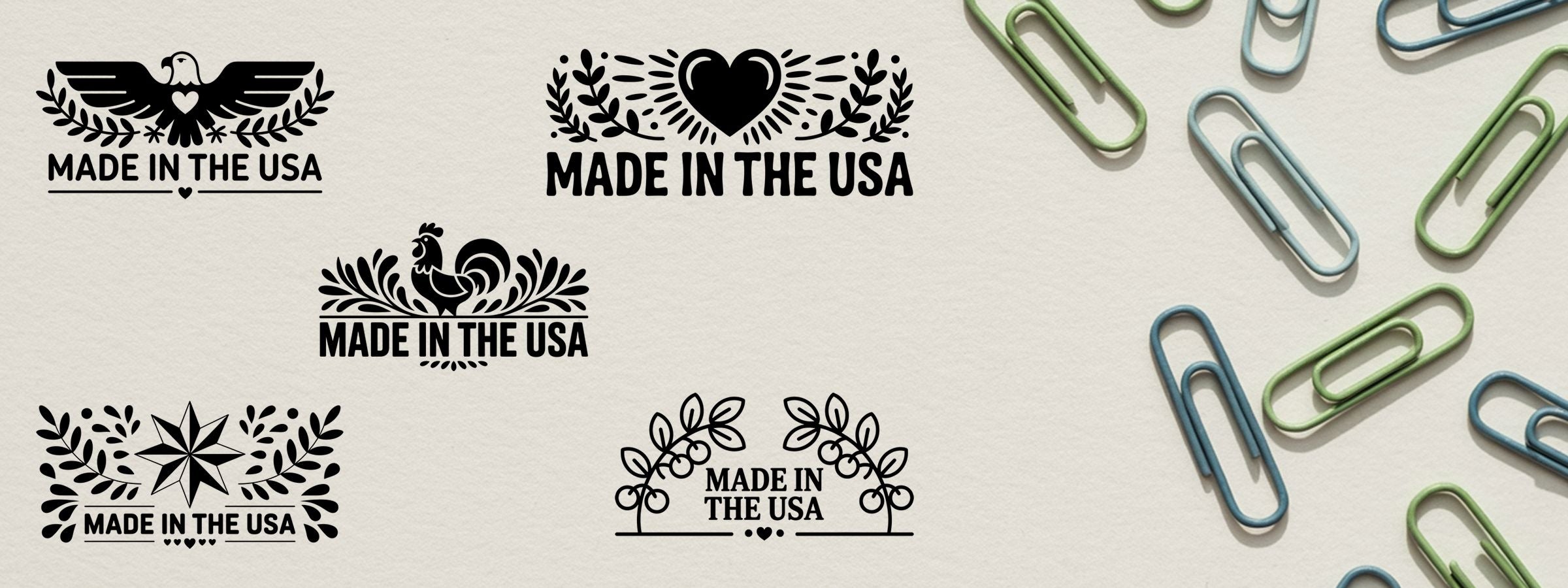 Folklore Made In USA Stamps featuring black eagle, heart, rooster, star, and floral wreath graphics on light paper with colored clips.