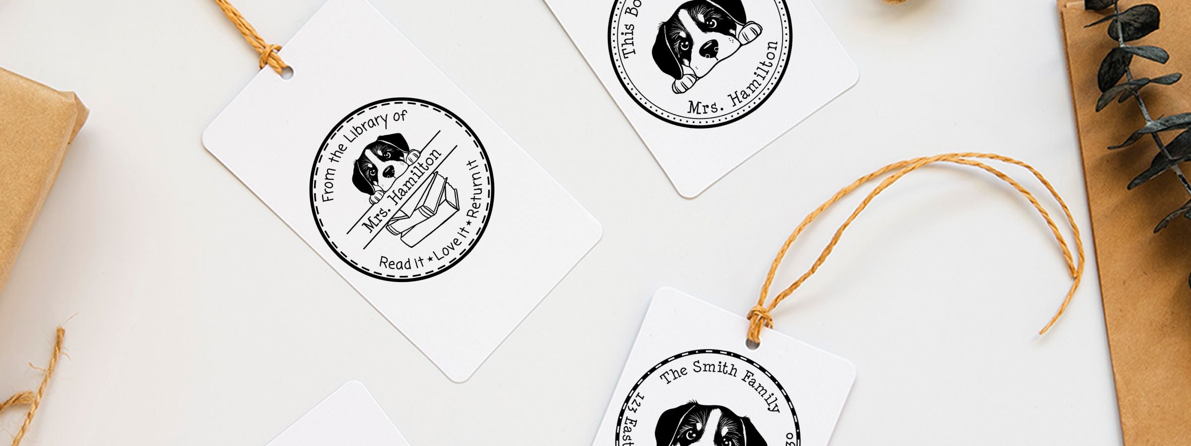 Flat lay of custom gift tags with Greater Swiss Mountain Dog Stamps and Custom Seals, featuring library-style text, twine, kraft paper, and eucalyptus.