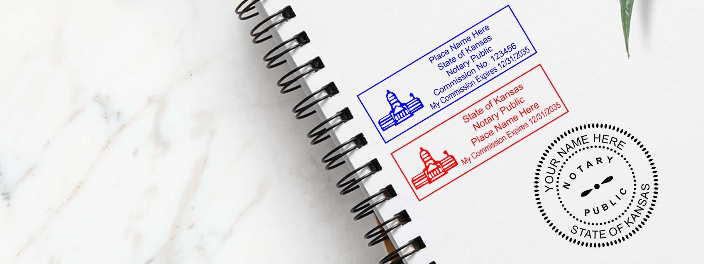 Open spiral notebook with Kansas Notary Supplies, Stamps and Seals blue and red notary stamp examples and a circular seal on white marble background.