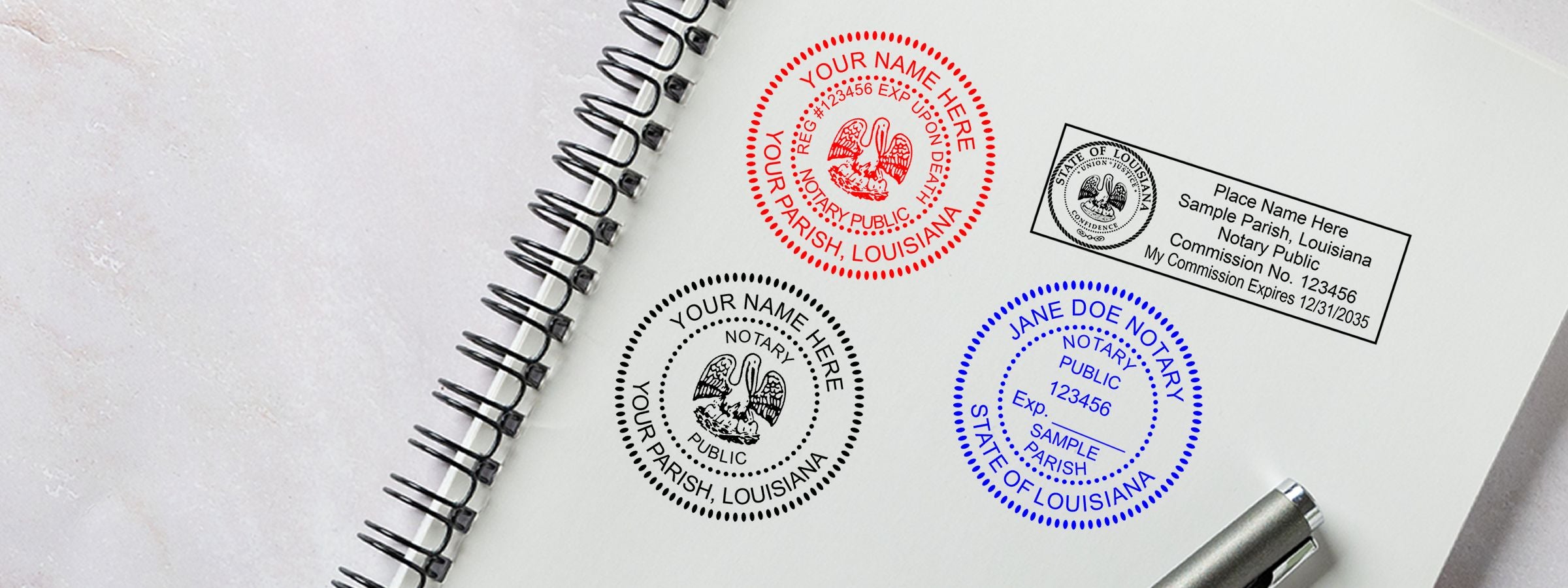 Open spiral notebook showing sample Louisiana Notary Supplies, Stamps and Seals designs in red, black, and blue with a stamp and pen.