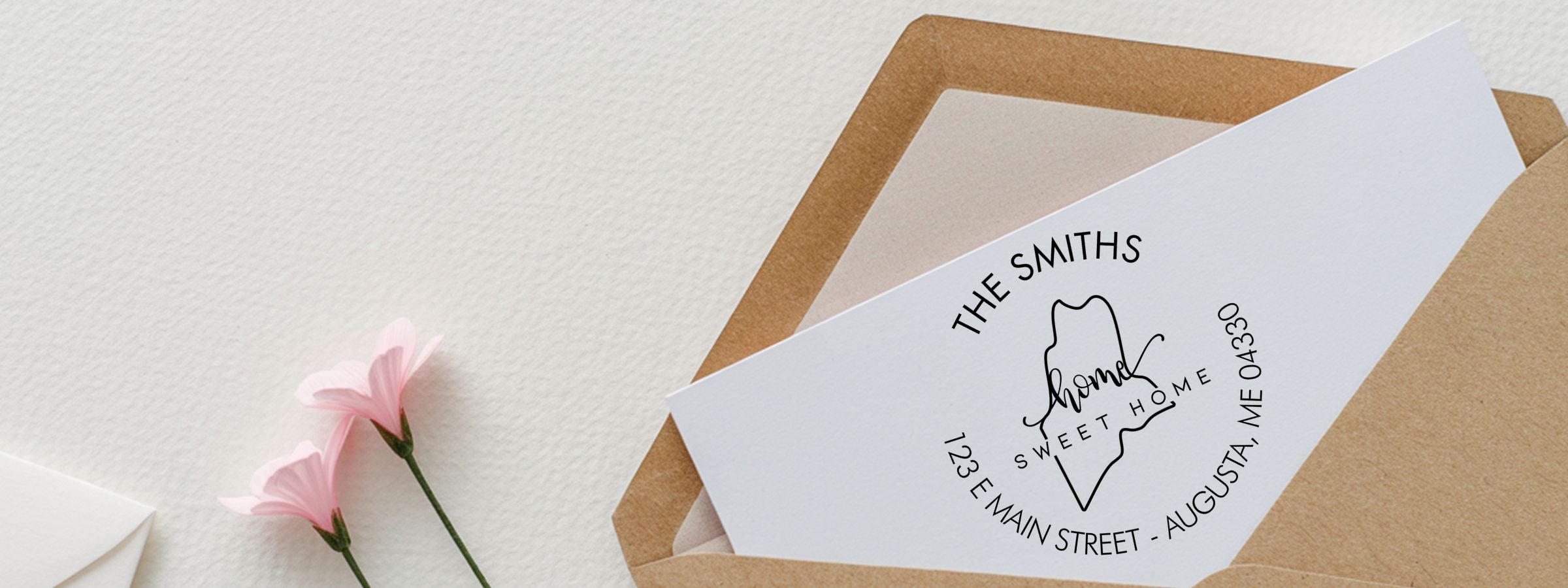 Brown kraft envelope with a white invitation card reading The Smiths Home Sweet Home, Augusta ME, from Maine Designer Stamps and Seals.