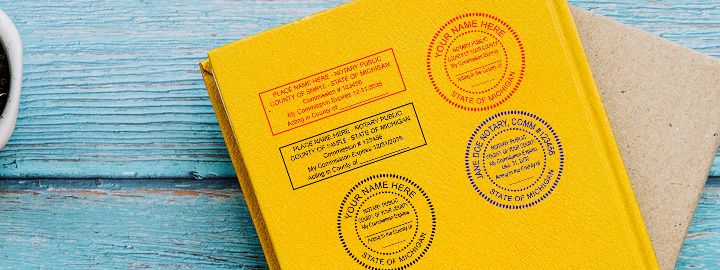 Yellow notary booklet on blue wood with Michigan Notary Supplies, Stamps and Seals sample stamps in red, black, and blue.