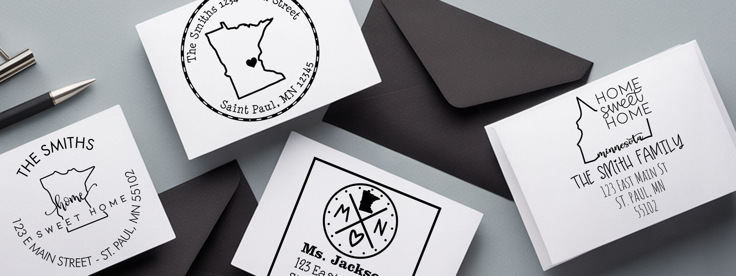 White envelopes and folded cards with Minnesota Designer Stamps and Seals, featuring home sweet home, family names, and St. Paul addresses.