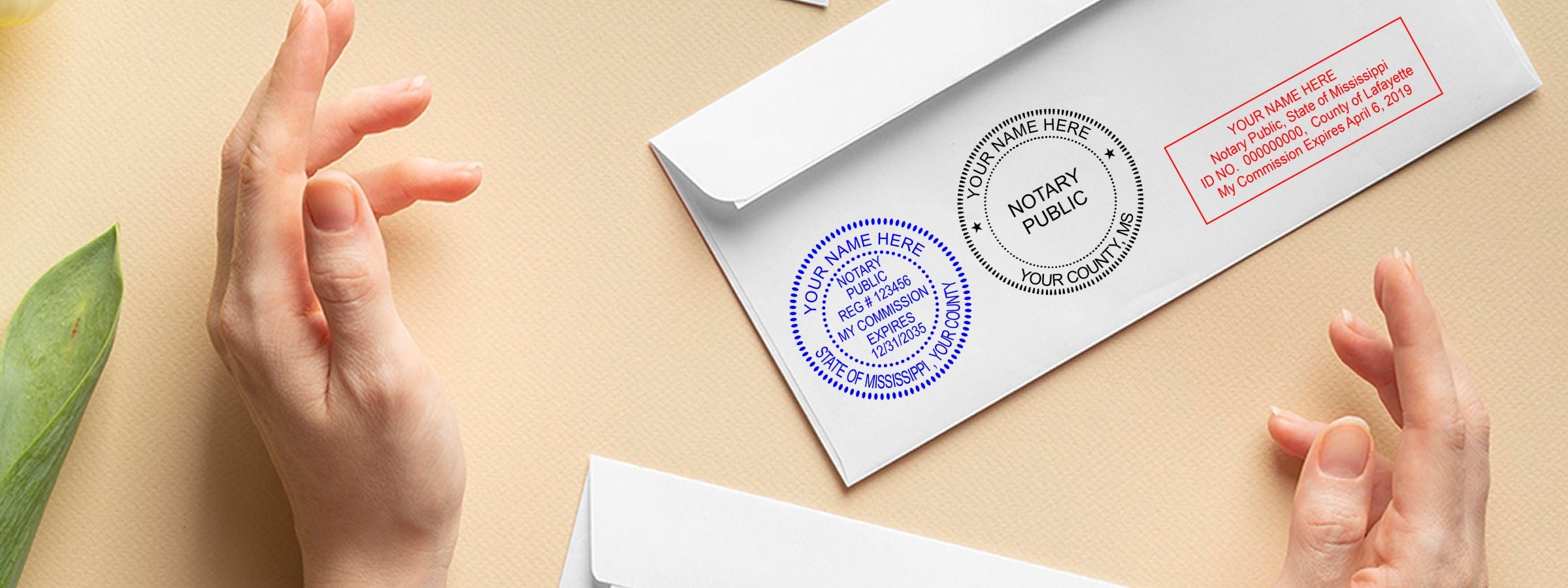 Hands beside envelopes with blue, black, and red notary stamp designs for Mississippi Notary Supplies, Stamps and Seals.