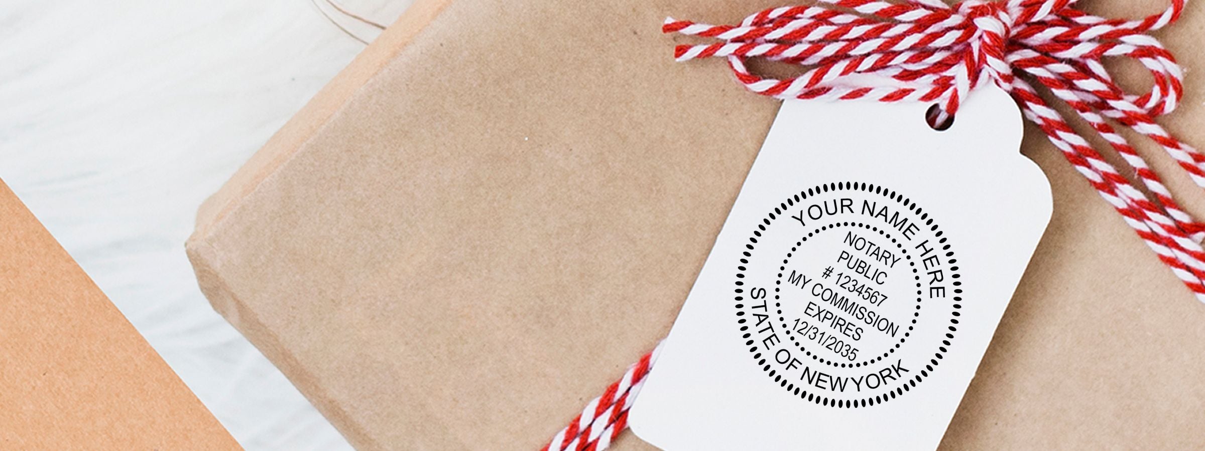 Wrapped gift box with white hang tag and red twine, featuring a New York notary public seal for New York Notary Supplies, Stamps and Seals.