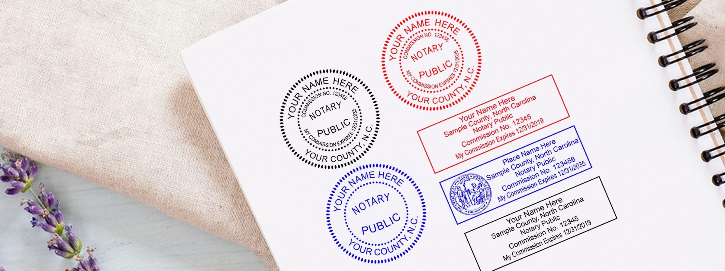 Spiral notebook with sample notary seal and stamp designs in black, red, and blue, plus lavender for North Carolina Notary Supplies, Stamps and Seals.