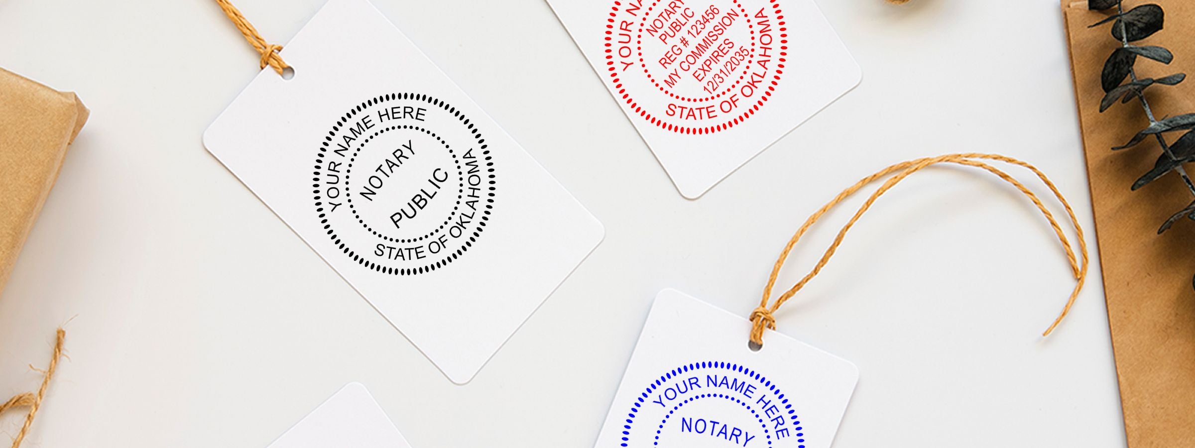 Three white hanging tags with customizable notary seal designs in black, red, and blue from Oklahoma Notary Supplies, Stamps and Seals.