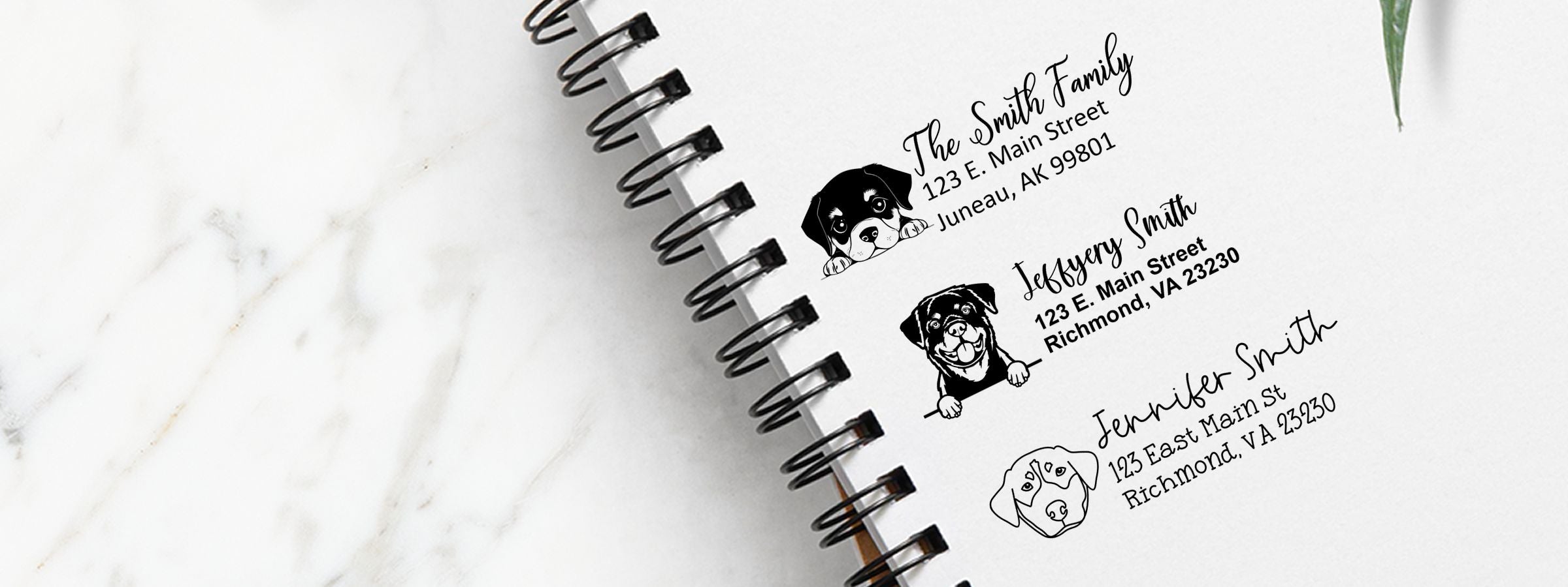 Spiral-bound notebook on white marble with personalized return address labels, dog illustrations, names, and Rottweiler Dog Stamps and Custom Seals.