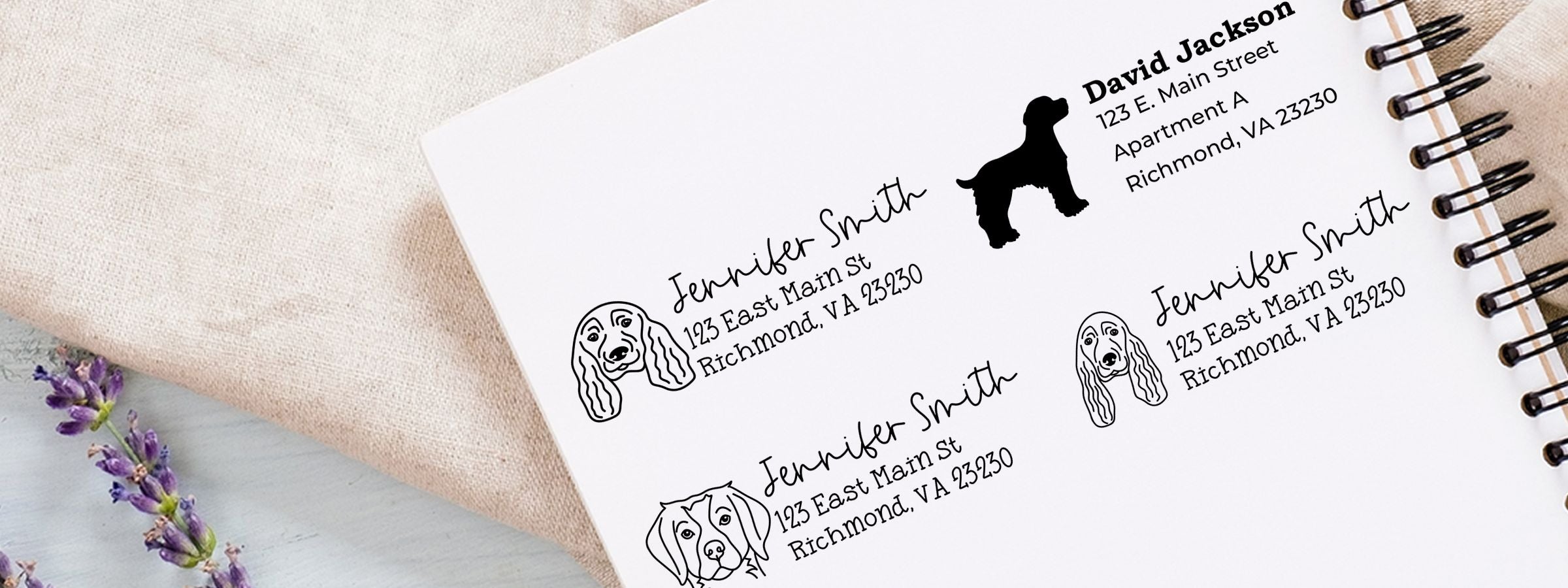 Spiral notebook page of Jennifer Smith mailing label designs with dog art, including Spaniel Dog Stamps and Custom Seals, on fabric with purple flowers.