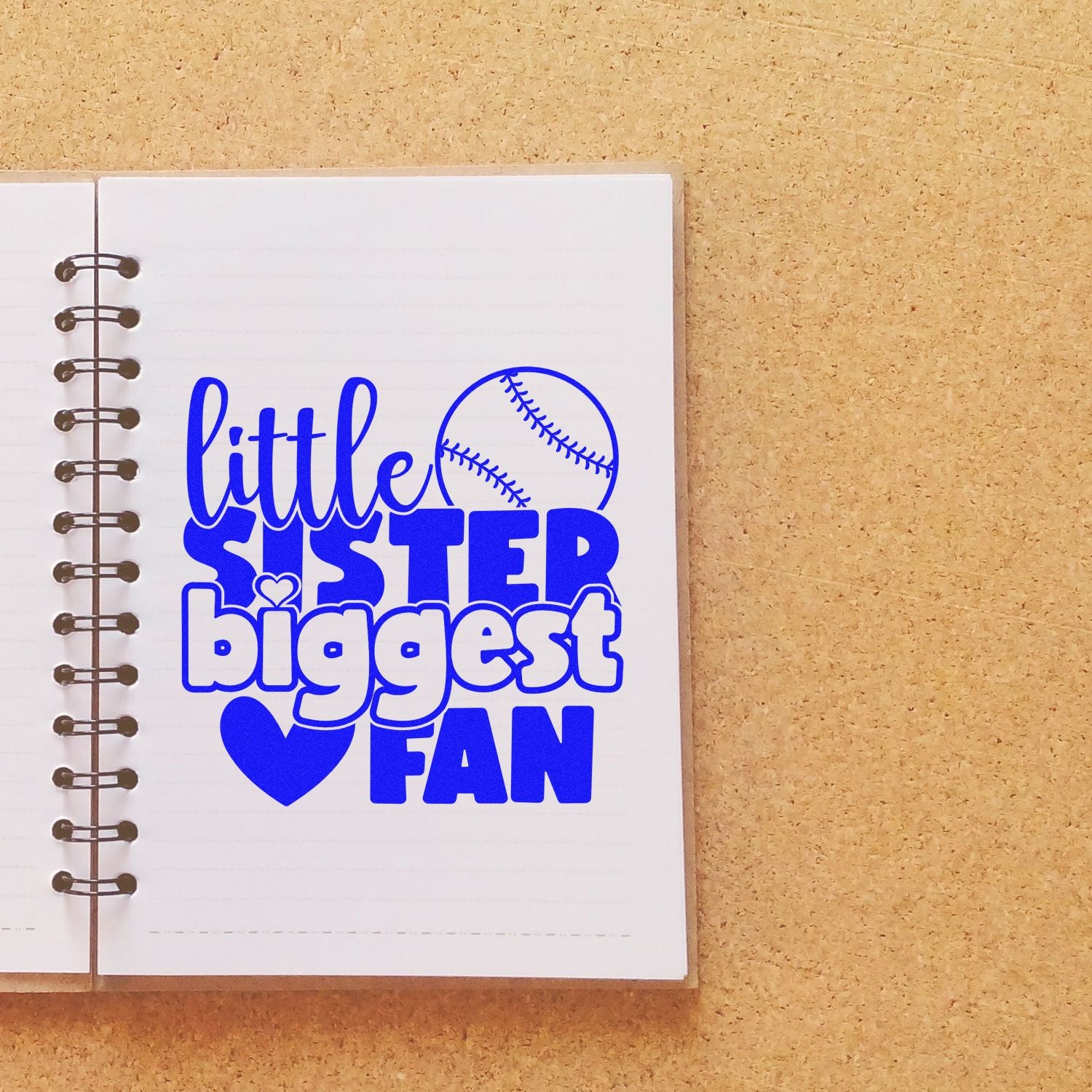 Little Sister Biggest Fan baseball rubber stamp design on notebook, ideal for sports-themed DIY crafts and scrapbooking.