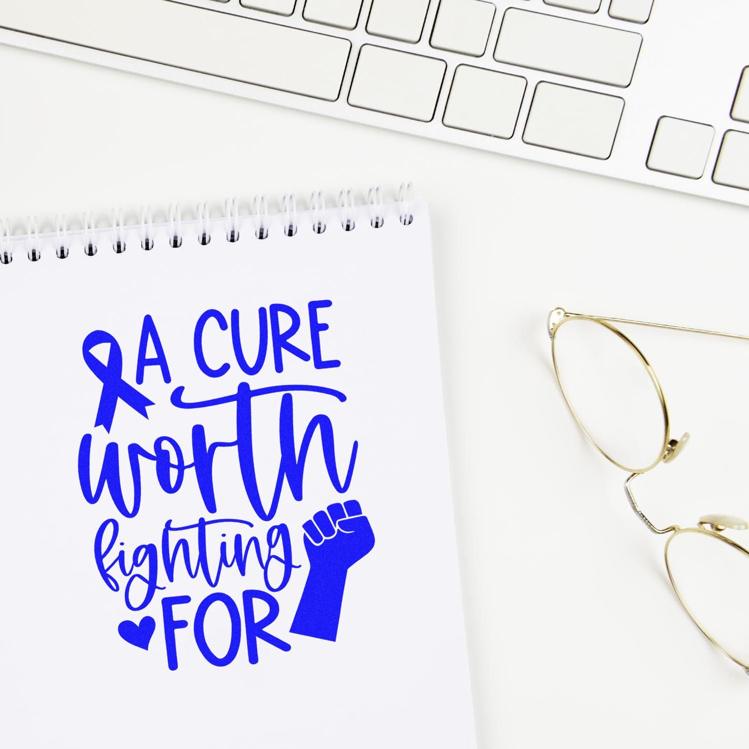 Breast cancer awareness rubber stamp design reading A cure worth fighting for with ribbon and fist on notebook.