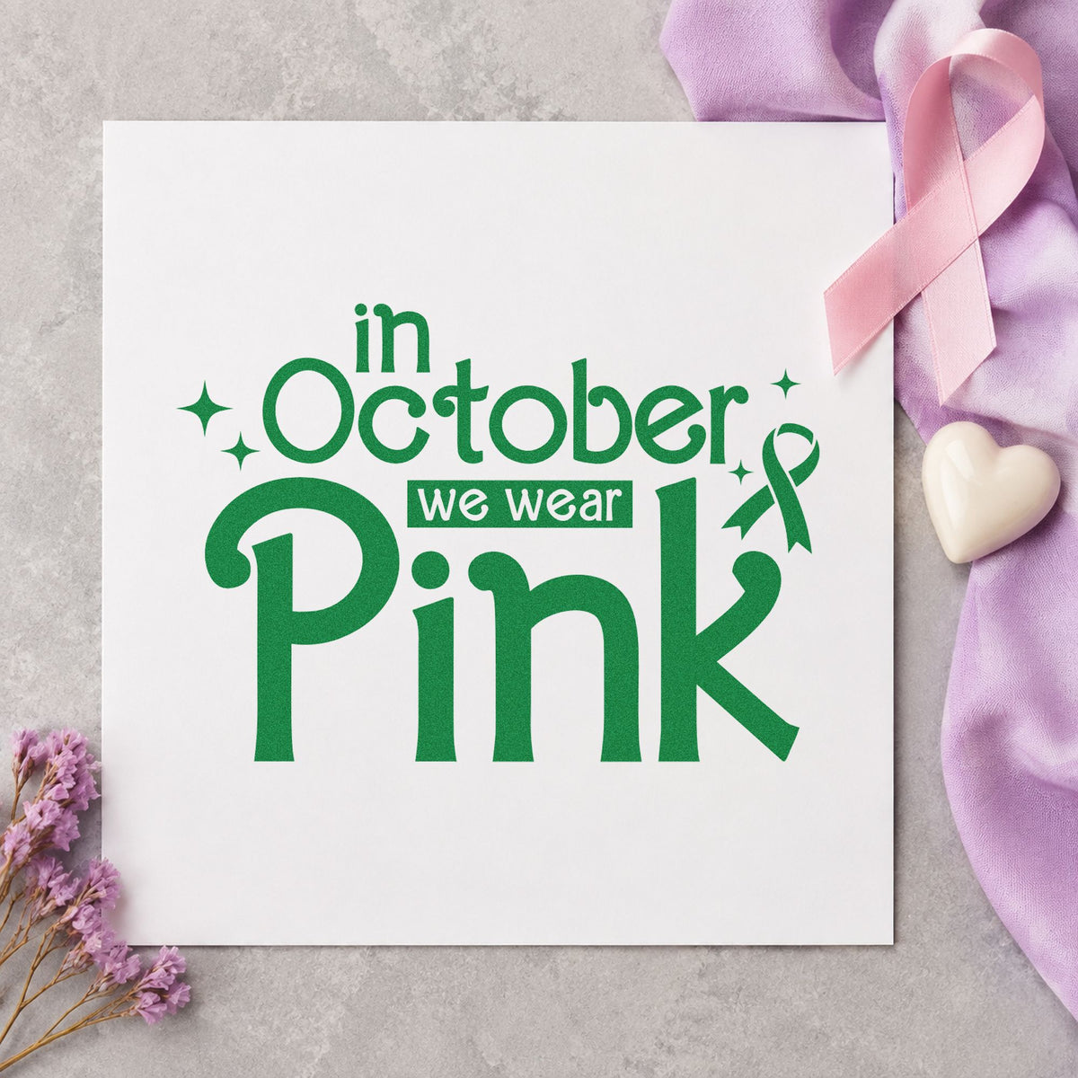 In October We Wear Pink craft stamp in green ink on cardstock, an easy option for office pink day signs.