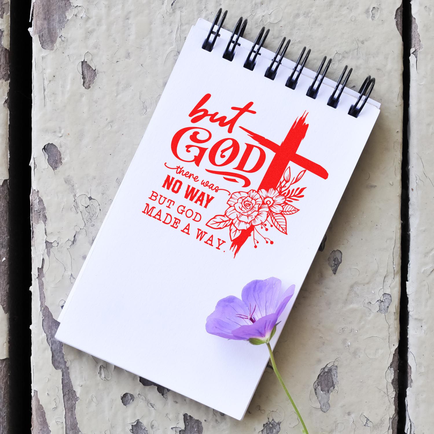 But God Christian rubber stamp design on a spiral notebook, with cross and flowers, for faith journaling and crafts.