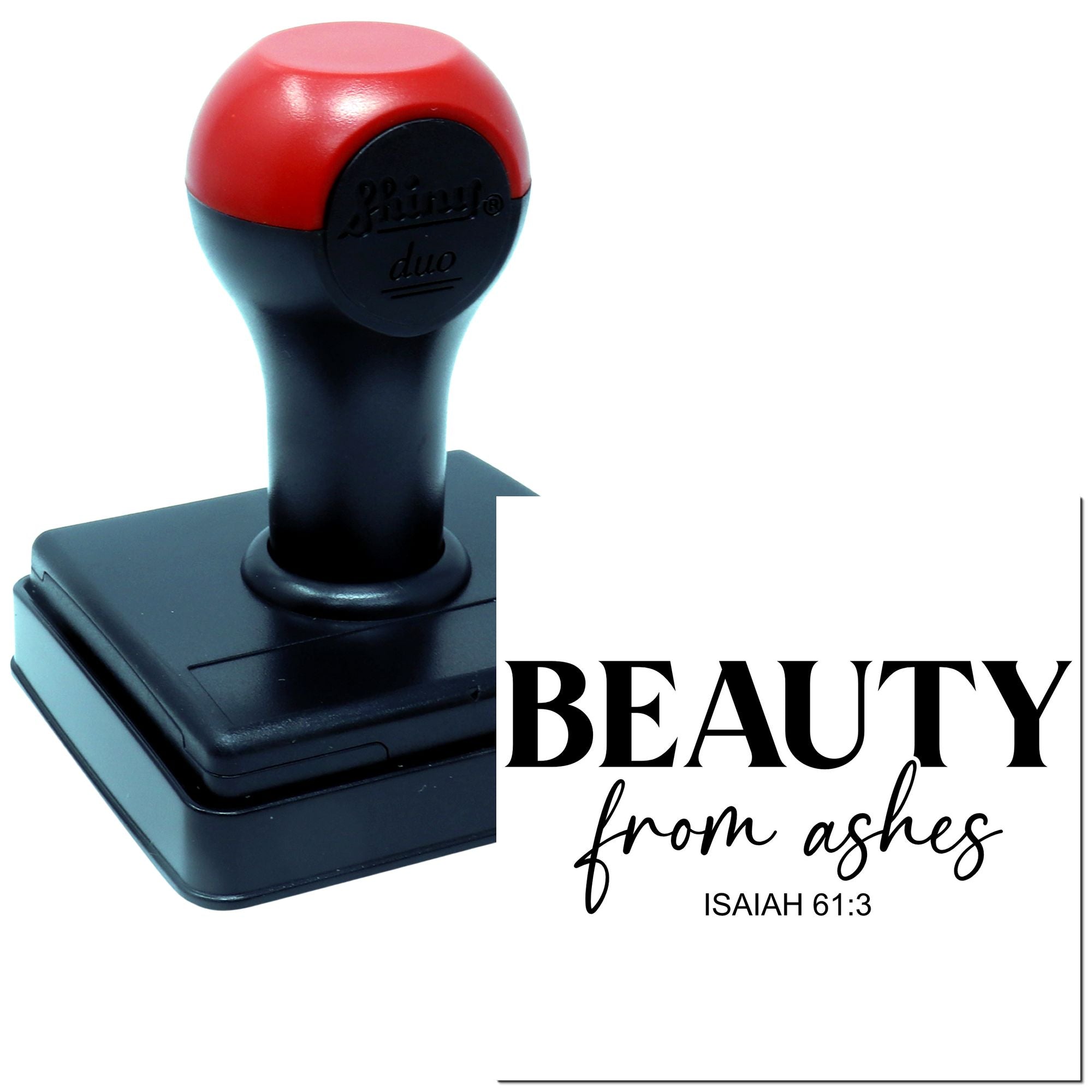 Self-inking rubber stamp imprint for Beauty from ashes Isaiah 61:3 design, red-and-black stamp on white background.