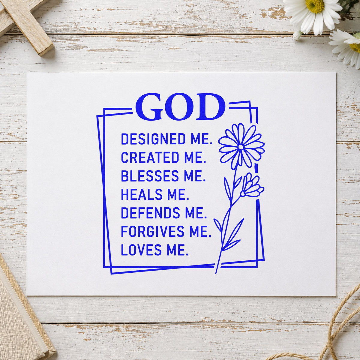 God Designed Me craft stamp imprinted in blue ink on paper, a design suited to onesie stamping.