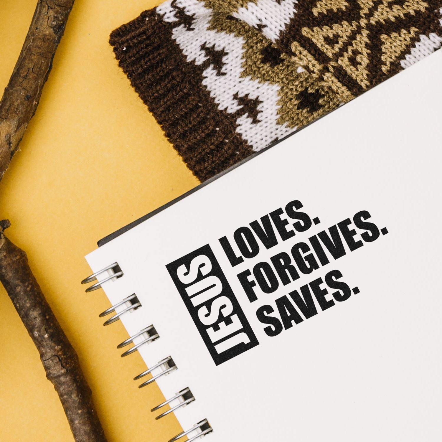 Christian rubber stamp design with Jesus Loves. Forgives. Saves. on a notebook, ideal for faith-based crafts and journaling.