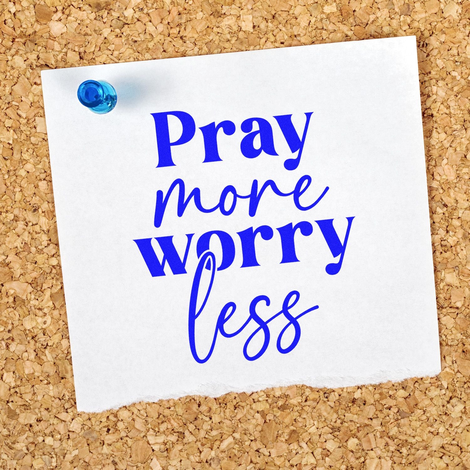 Blue Pray more worry less rubber stamp design on paper pinned to corkboard, ideal for faith-based cards and crafts.