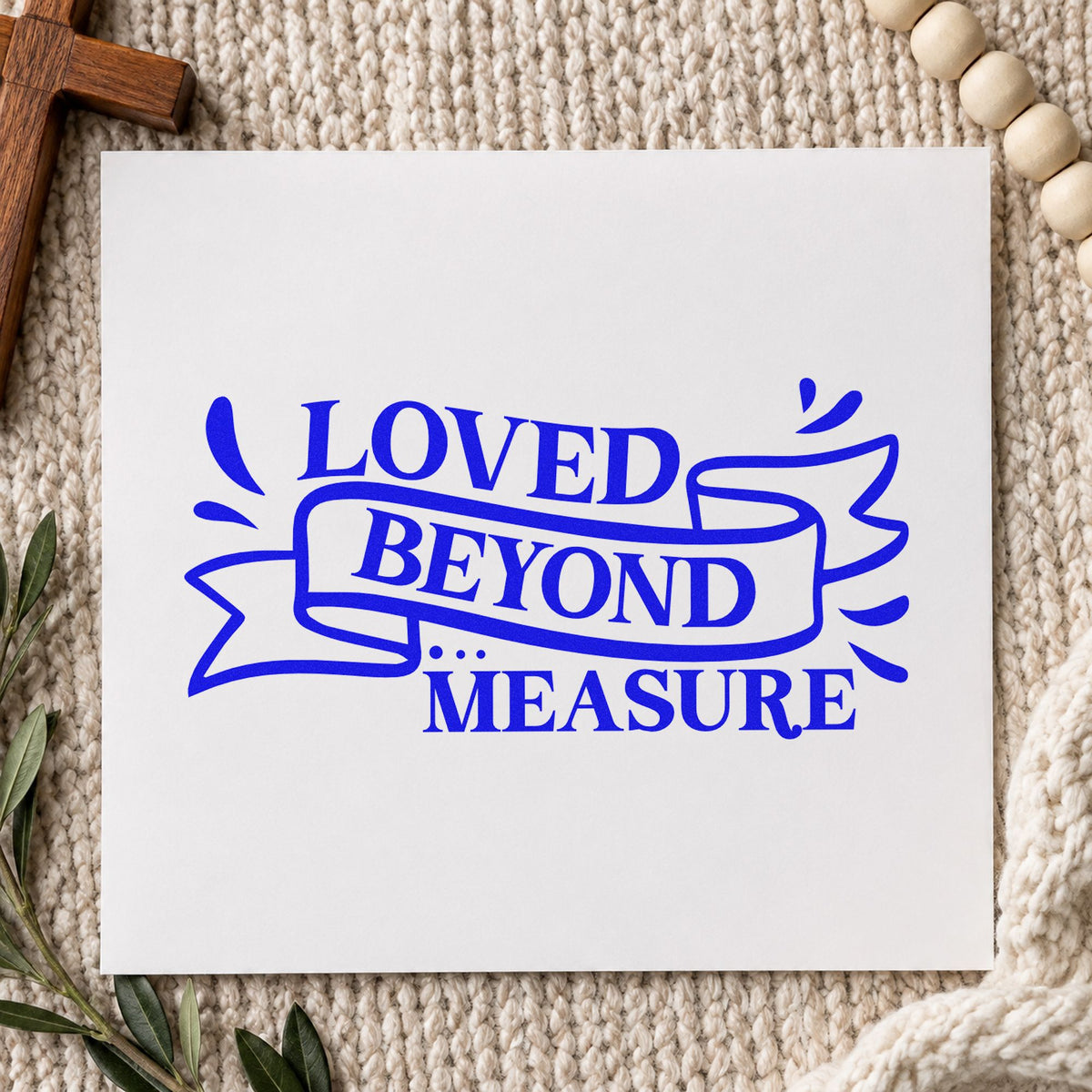 Loved Beyond Measure Ribbon craft stamp in blue ink on cardstock, an easy option for onesie stamping.