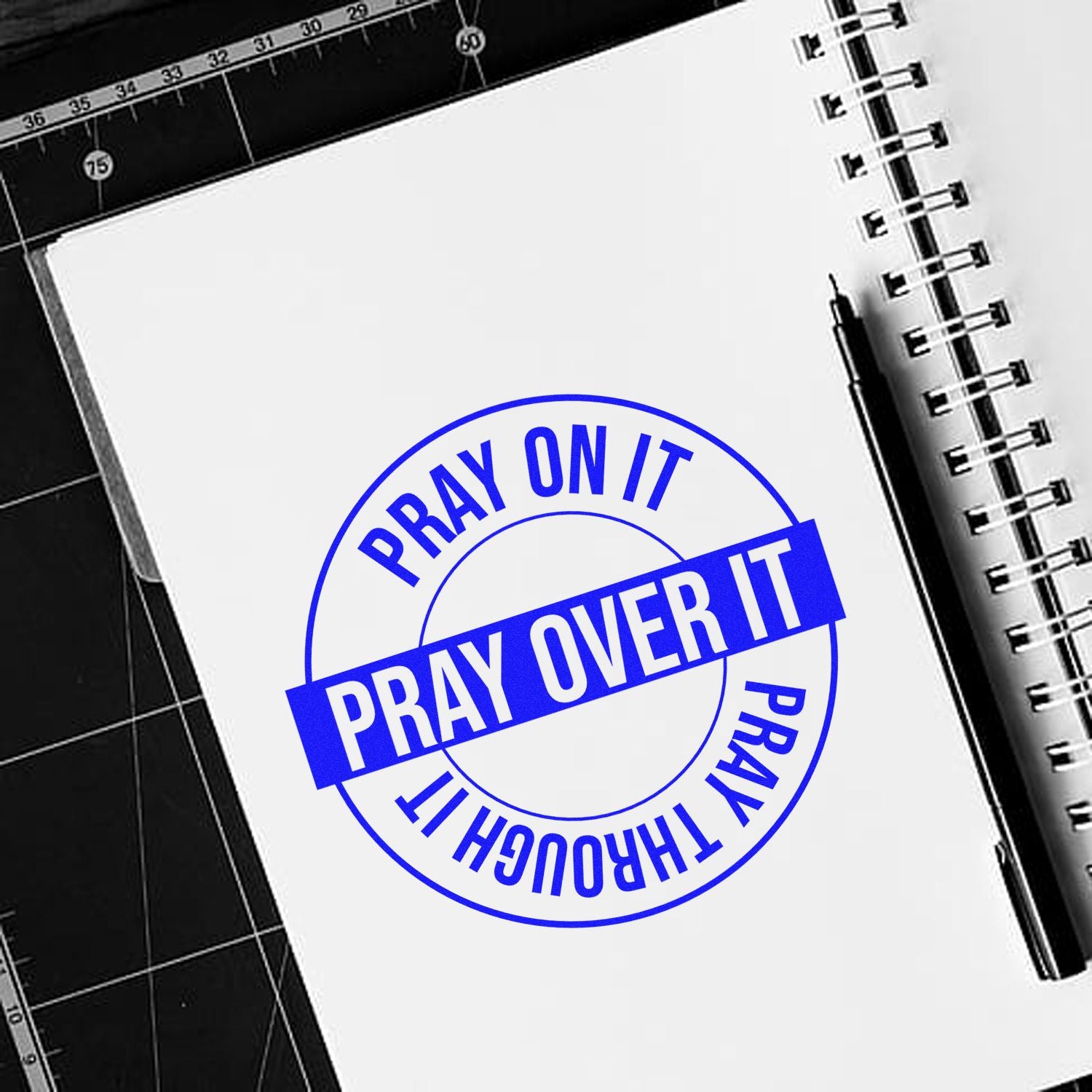 Custom rubber stamp design with blue Pray On It, Pray Over It, Pray Through It faith quote on notebook page.
