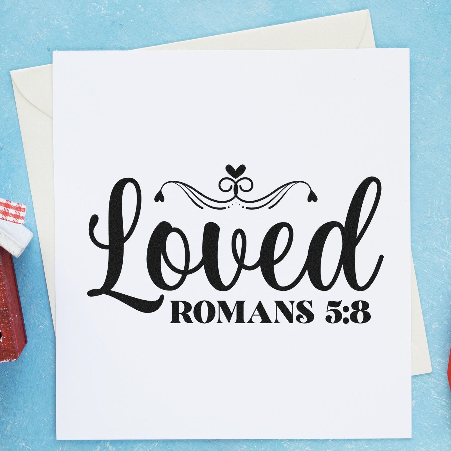 Christian rubber stamp design with Loved Romans 5:8 on a greeting card, ideal for faith-based card making.