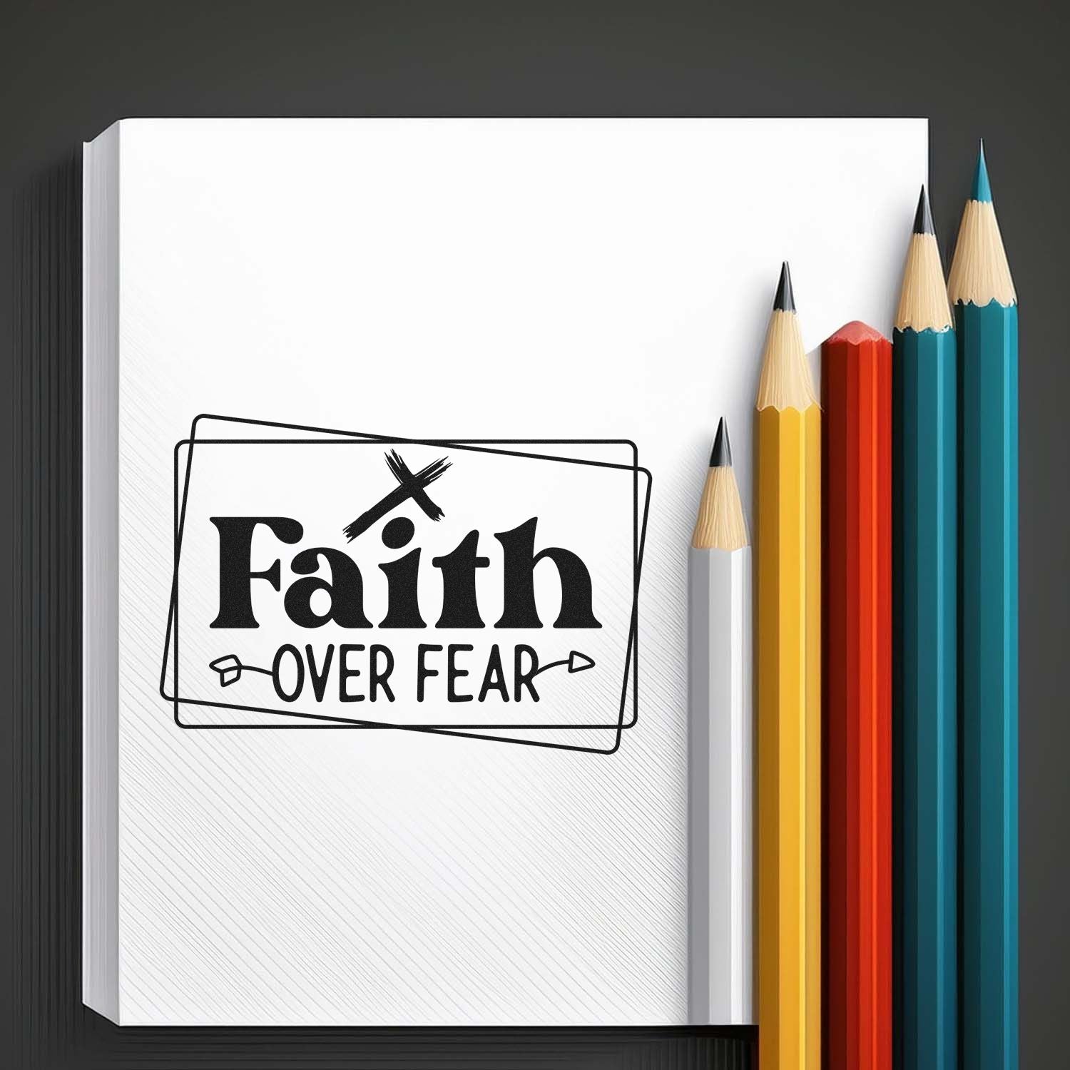 Faith Over Fear rubber stamp design on notebook with colored pencils, inspiring Christian craft and journaling.
