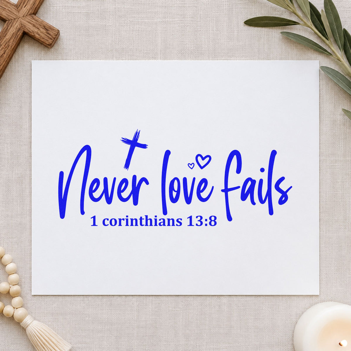 Never Love Fails craft stamp imprinted in blue ink on paper, a design suited to ring box labels.