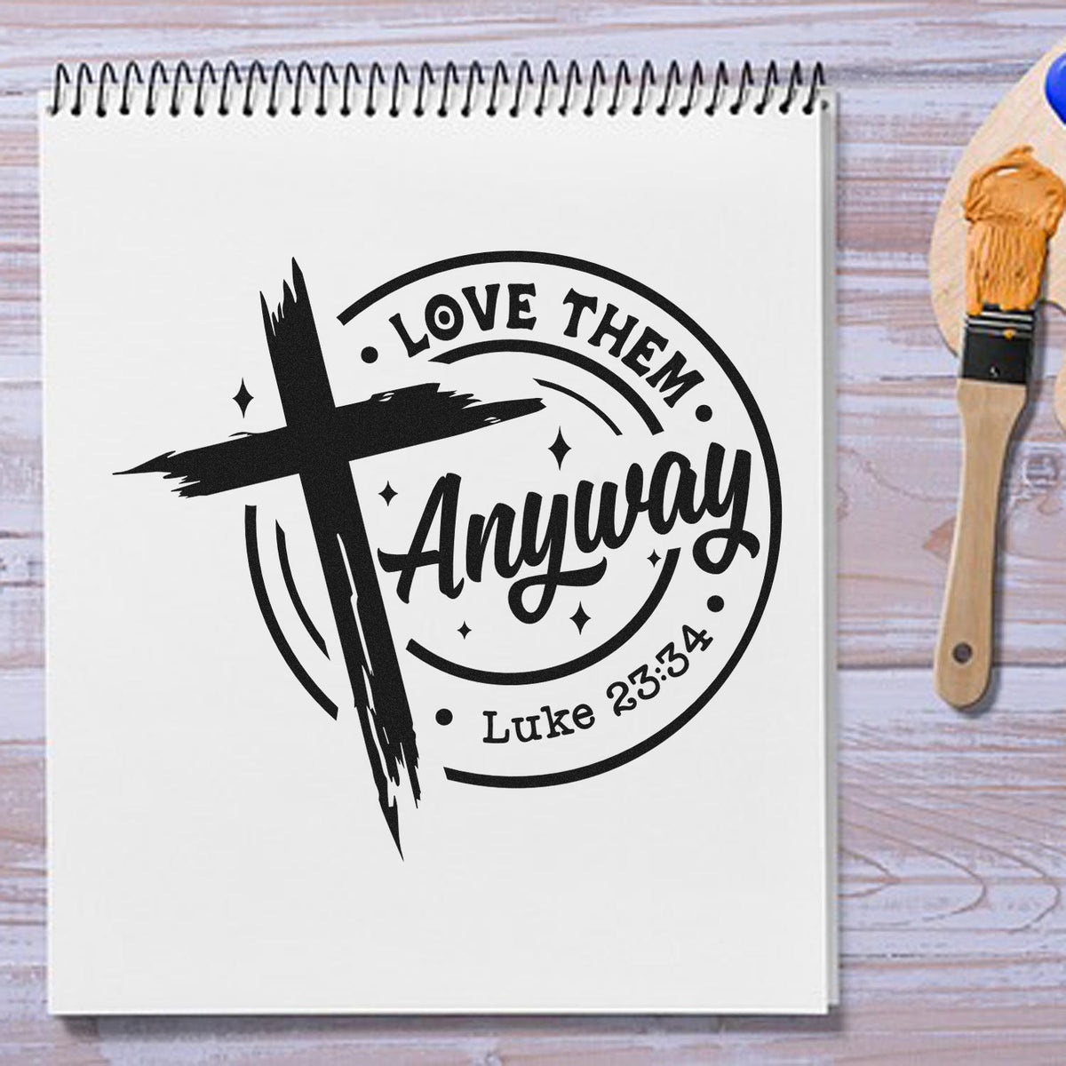 Love Them Anyway Premium Wood-Mounted Stamp - Vintage Pro imprint stamped in black ink. A brushstroke cross overlaps a circular "Love them anyway" design with Luke 23:34.