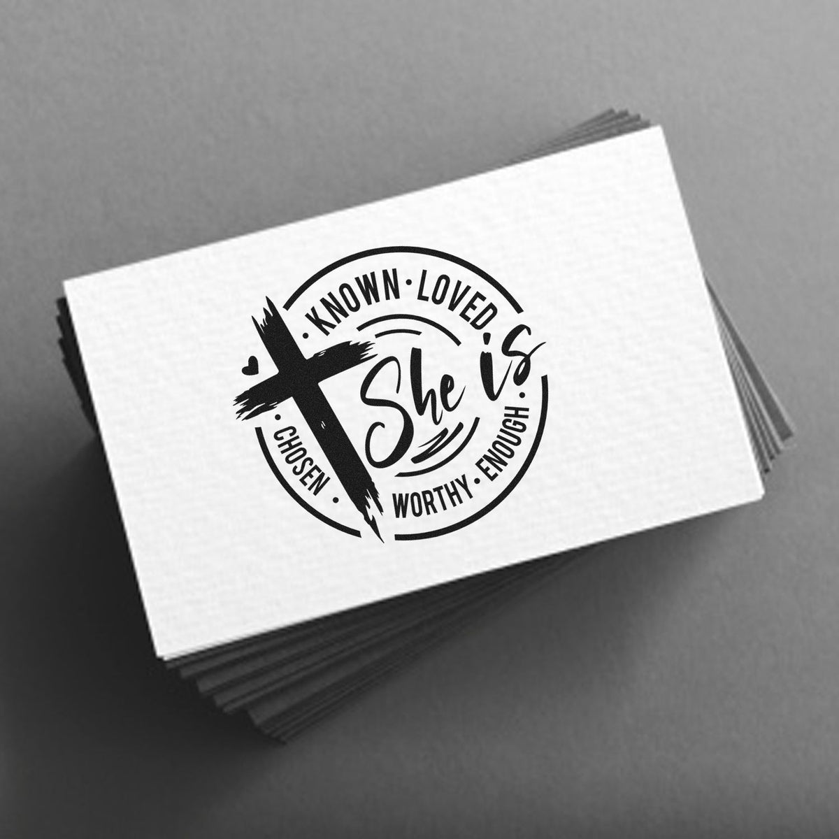 She Is Known Loved Worthy Premium Wooden Stamp - Vintage Pro imprint stamped in black ink. A brushstroke cross overlaps a "She is" badge bordered by "Known," "Loved," "Chosen," "Worthy," and "Enough."
