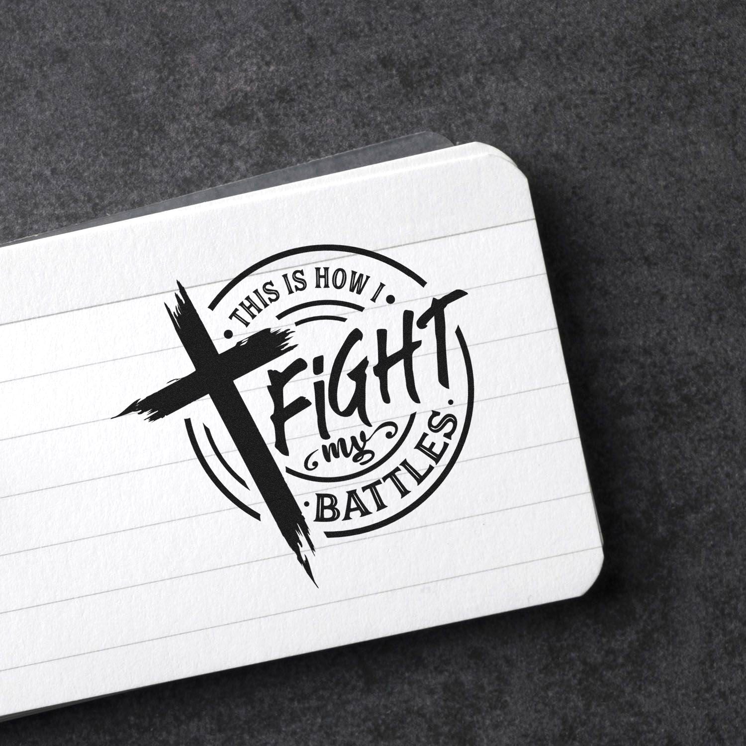 Custom rubber stamp design with This Is How I Fight My Battles and cross artwork on a lined notebook page.
