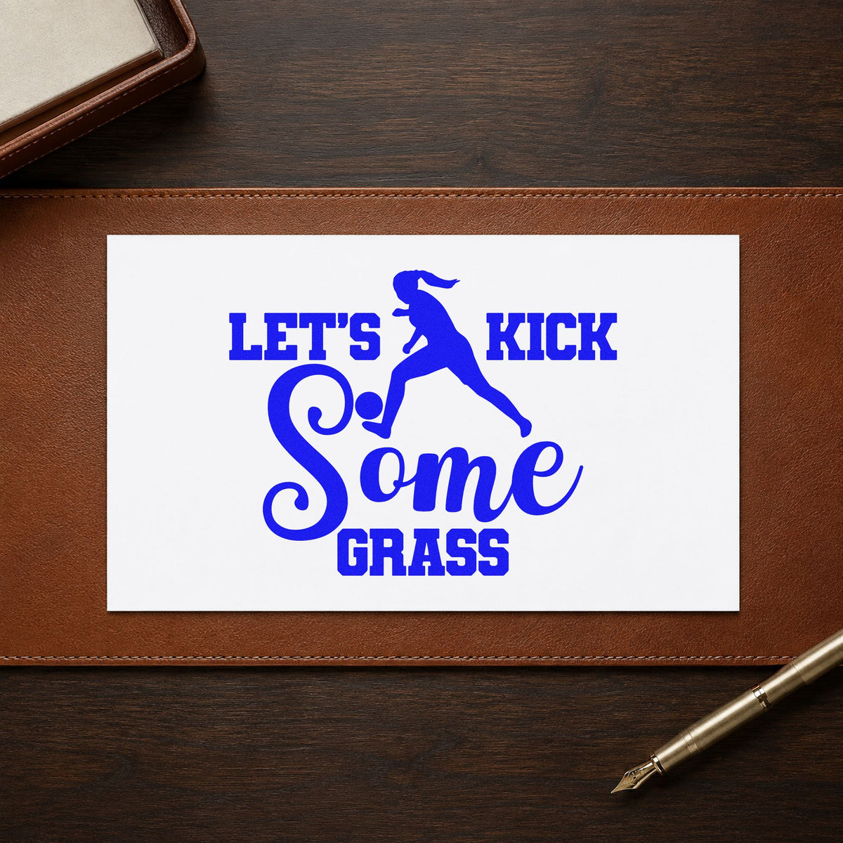 Let's Kick Some Grass craft stamp imprinted in blue ink on paper, a design suited to tailgate cup bands.
