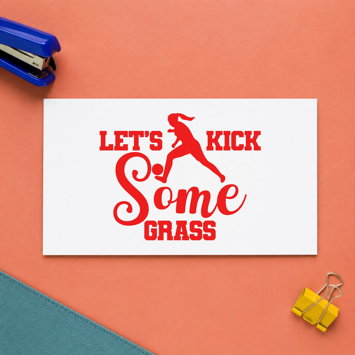 Let's Kick Some Grass rubber stamp shown in red ink, stamped for projects such as rivalry week notes.