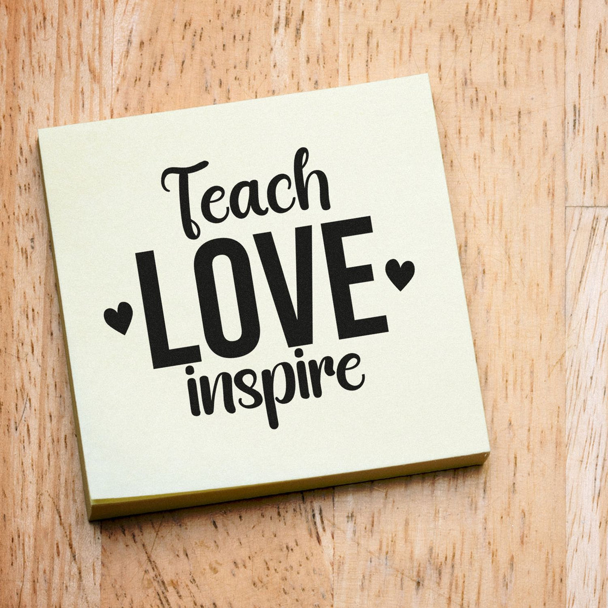 Premium Wooden Teach Love Inspire With Hearts Stamp - Vintage Pro imprint stamped in black ink. Two hearts flank large "Love" lettering between "Teach" and "Inspire."