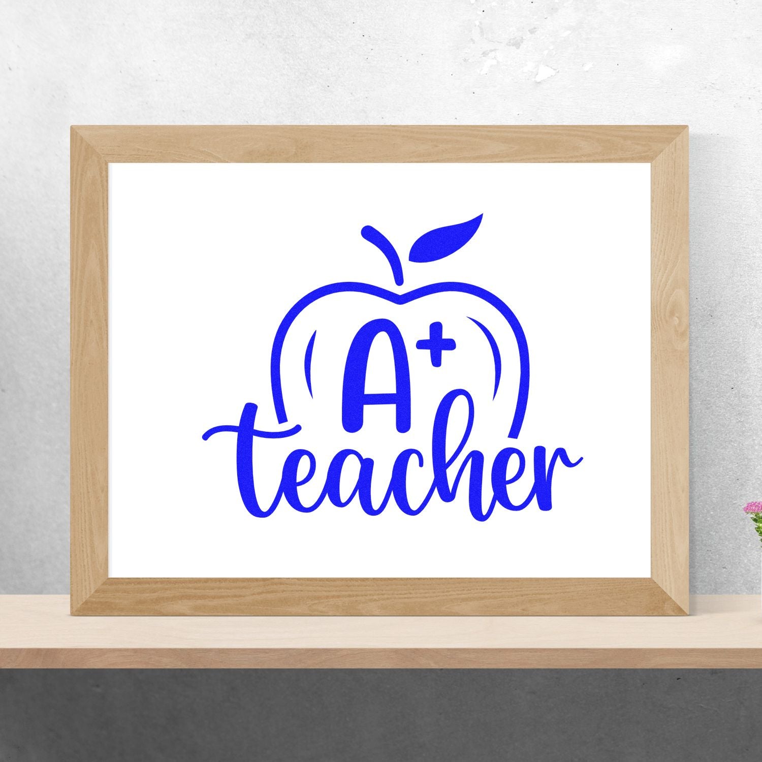 A+ Teacher apple design for custom rubber stamps, blue classroom education logo mockup in a wood frame.