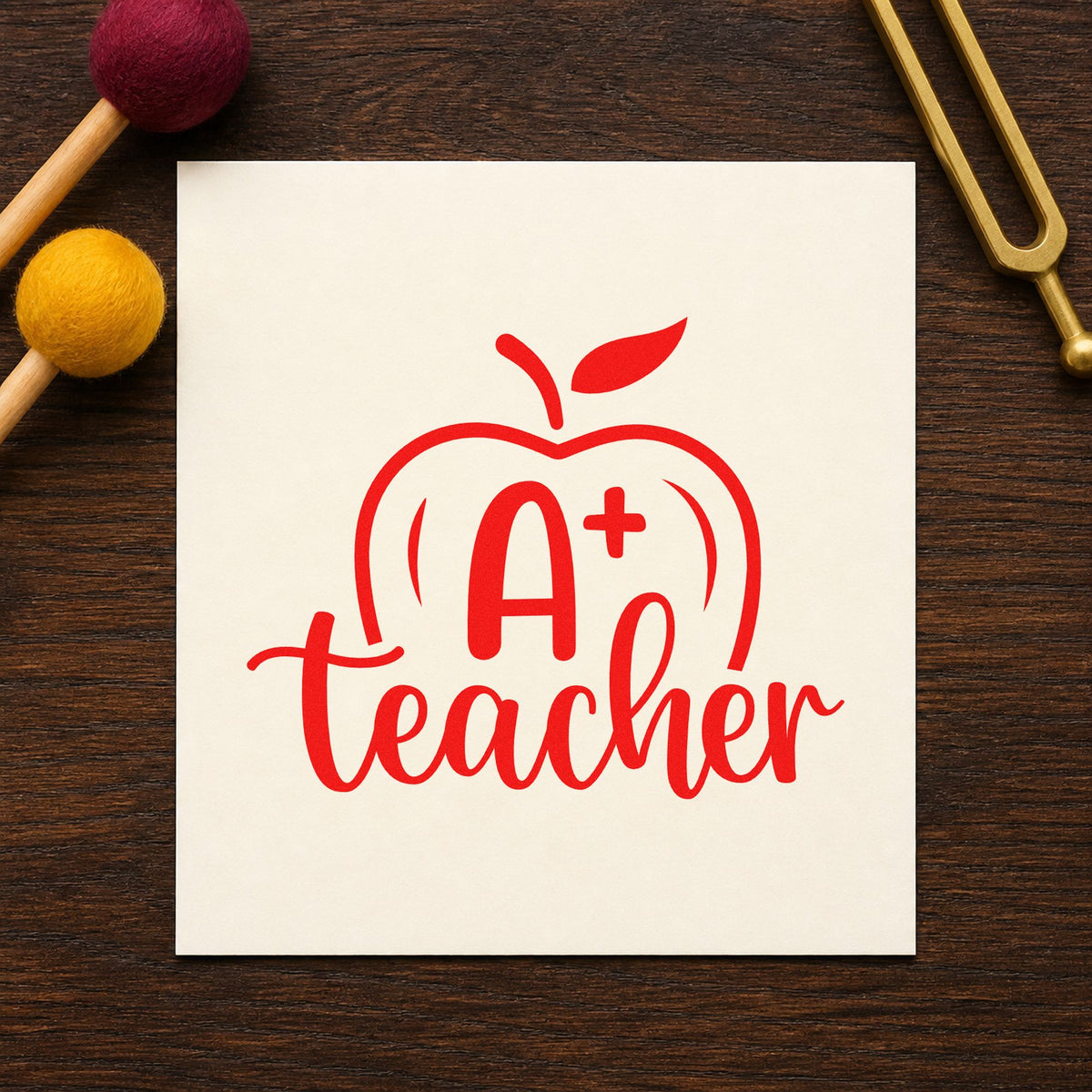 A Plus Teacher Apple rubber stamp shown in red ink, stamped for projects such as parent conference notes.