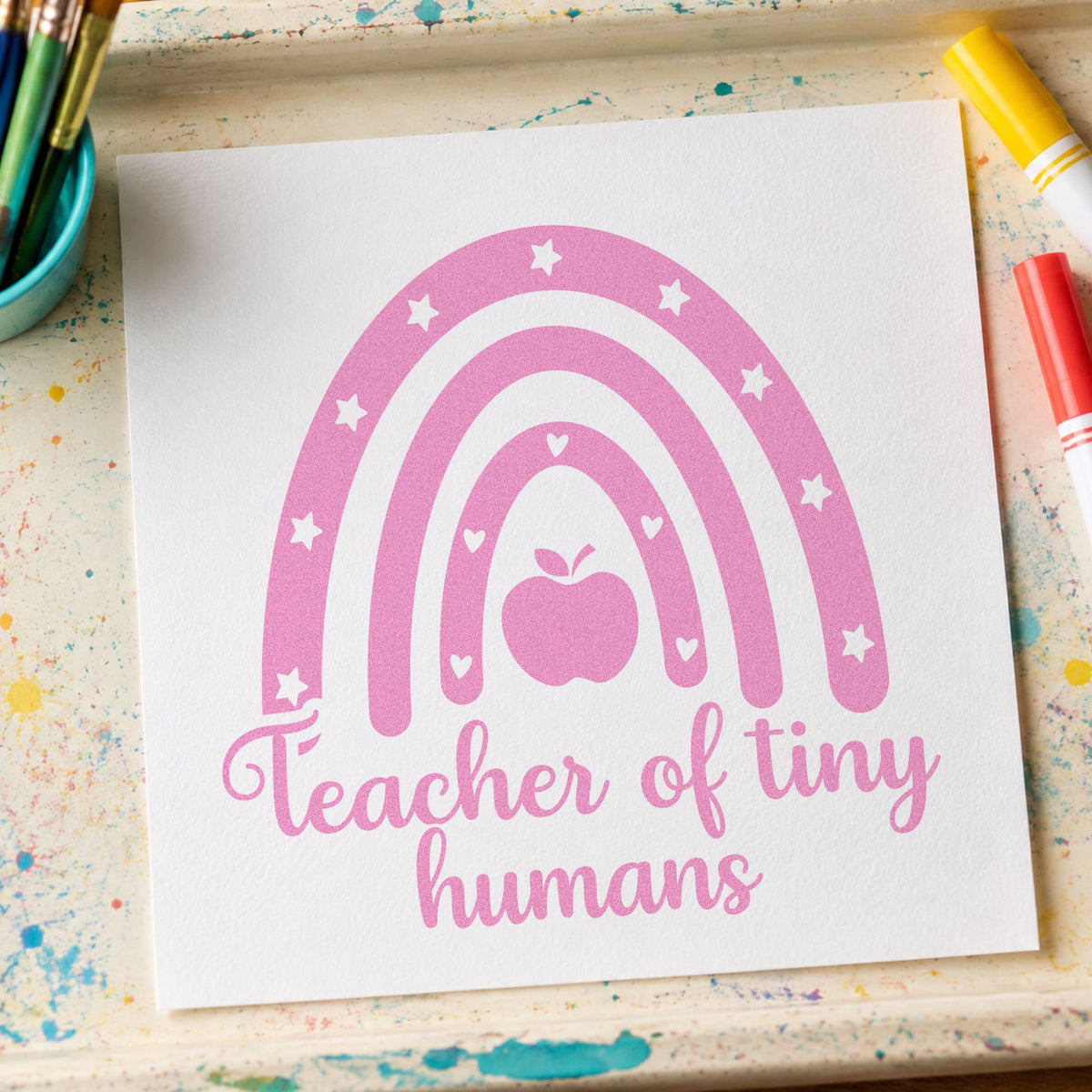 Teacher of Tiny Humans Rainbow craft stamp in purple ink on cardstock, an easy option for nap chart tags.