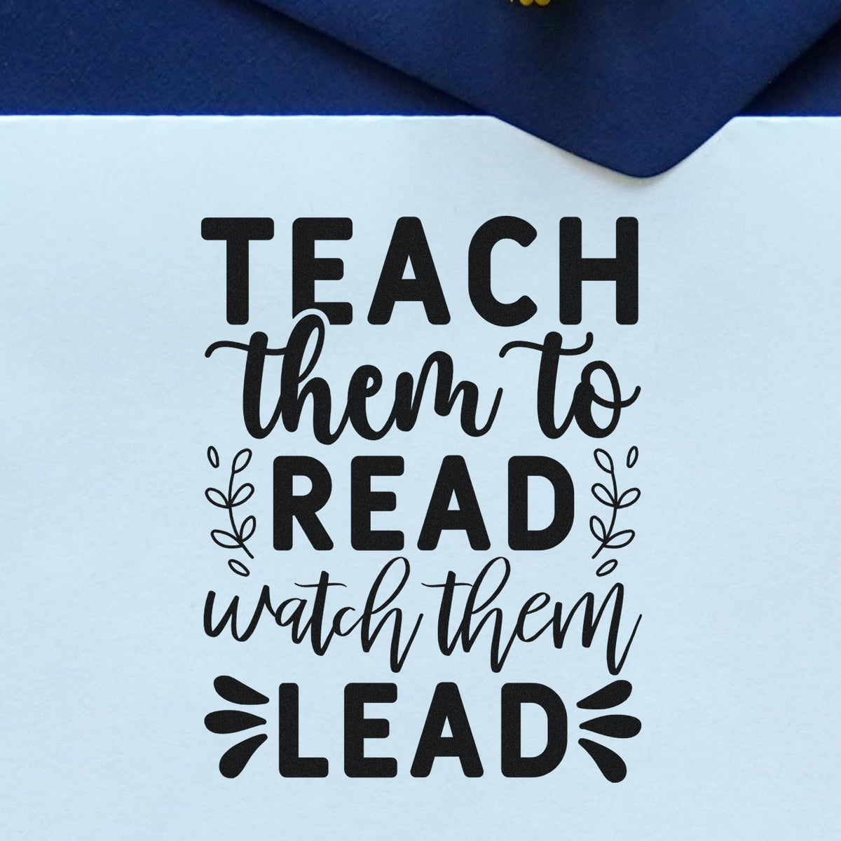 Teach Read Watch Lead Premium Wooden Stamp - Vintage Pro imprint stamped in black ink. "Teach Them to Read Watch Them Lead" features leafy sprigs and decorative rays.