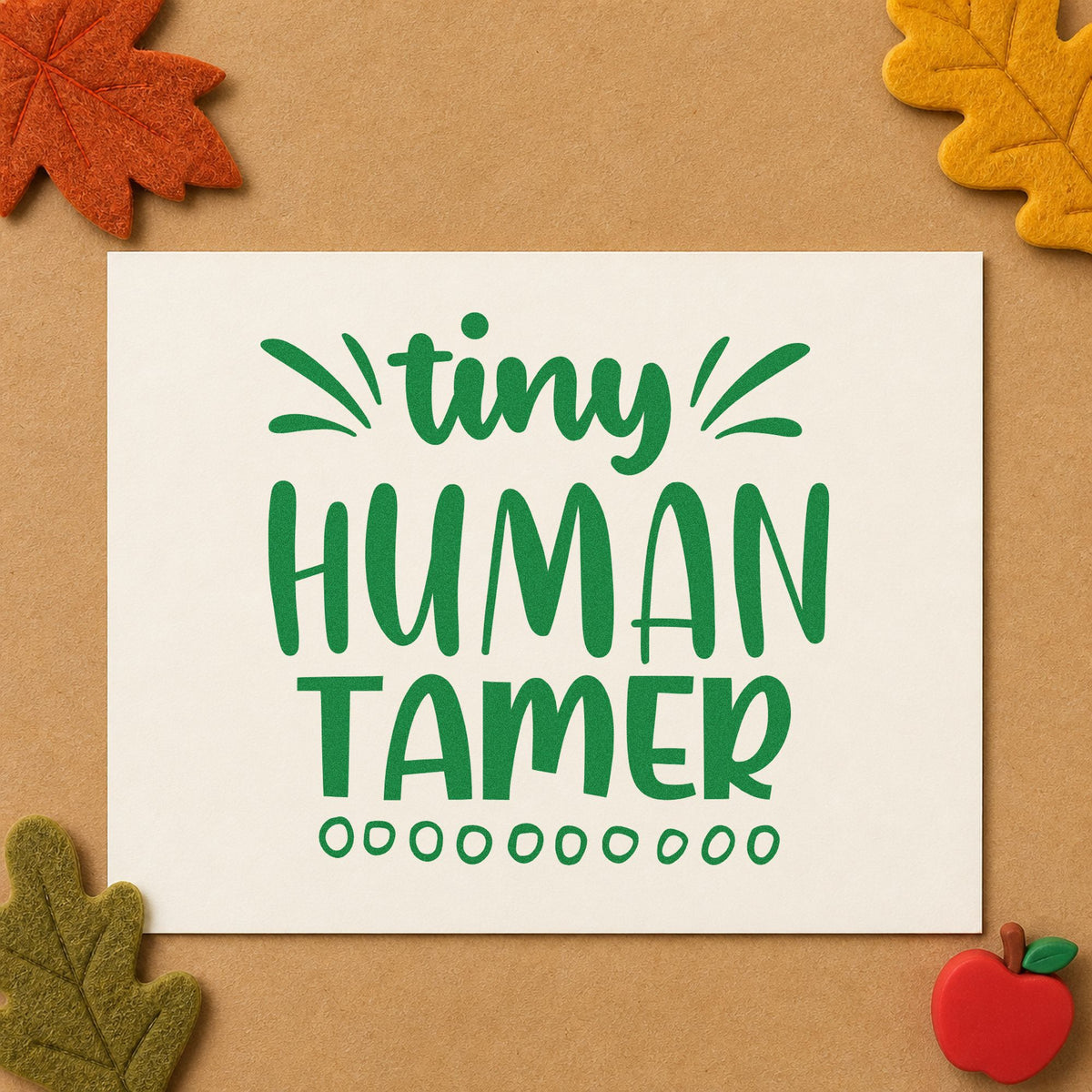 Tiny Human Tamer Lettering craft stamp imprint in green ink on a handmade project, one idea being framed play corner.