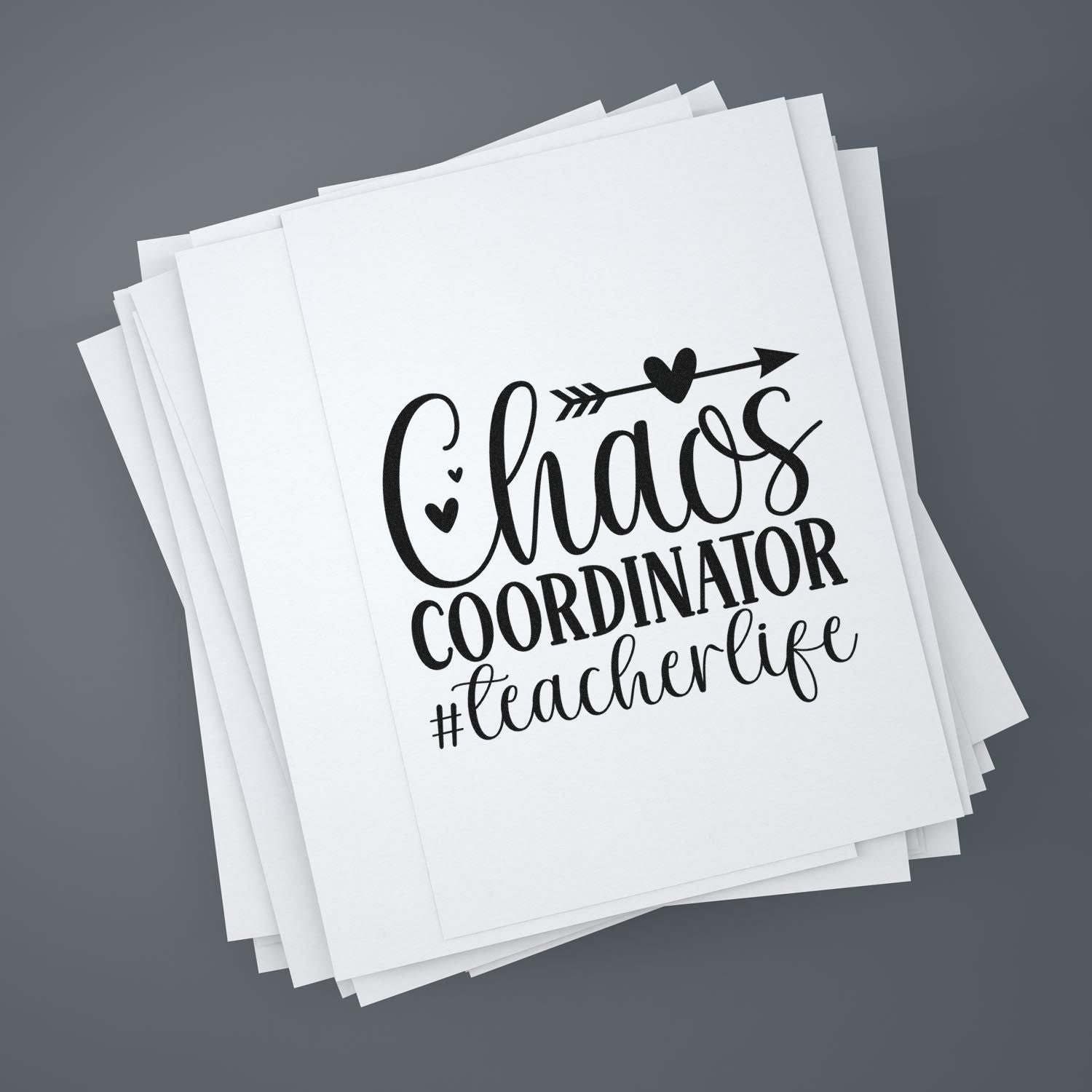 Chaos Coordinator #teacherlife rubber stamp design for teachers, with heart and arrow graphic on stacked white paper.