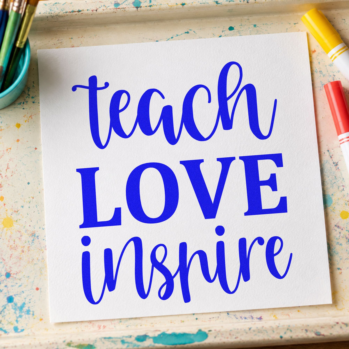 Teach Love Inspire Simple Script craft stamp in blue ink on cardstock, an easy option for ribbon rosette panels.