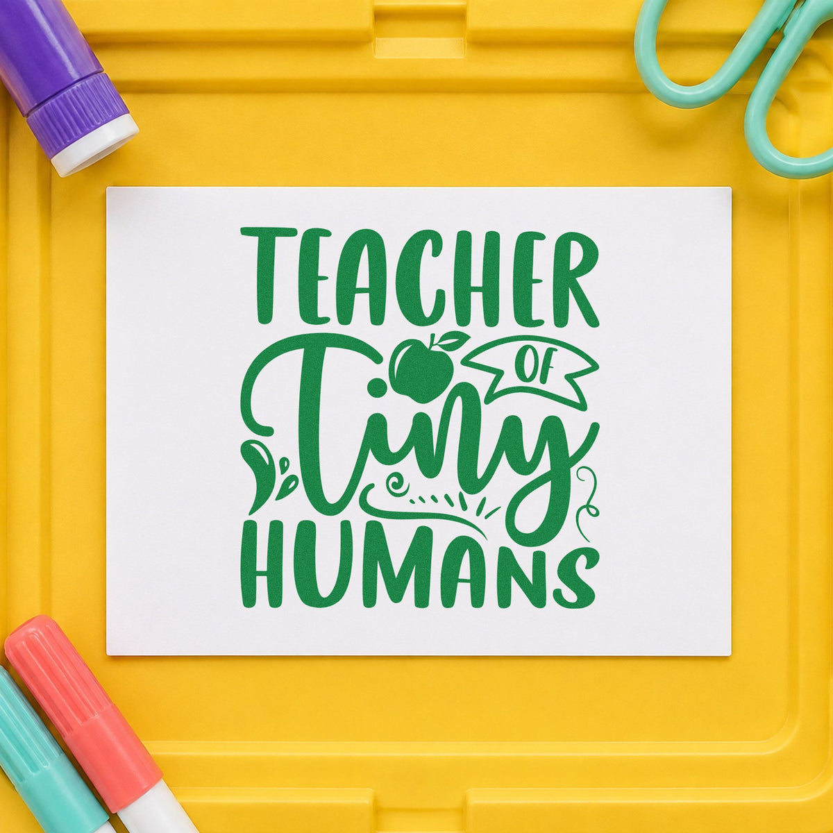 Teacher Of Tiny Humans Apple craft stamp imprint in green ink on a handmade project, one idea being baby book pages.