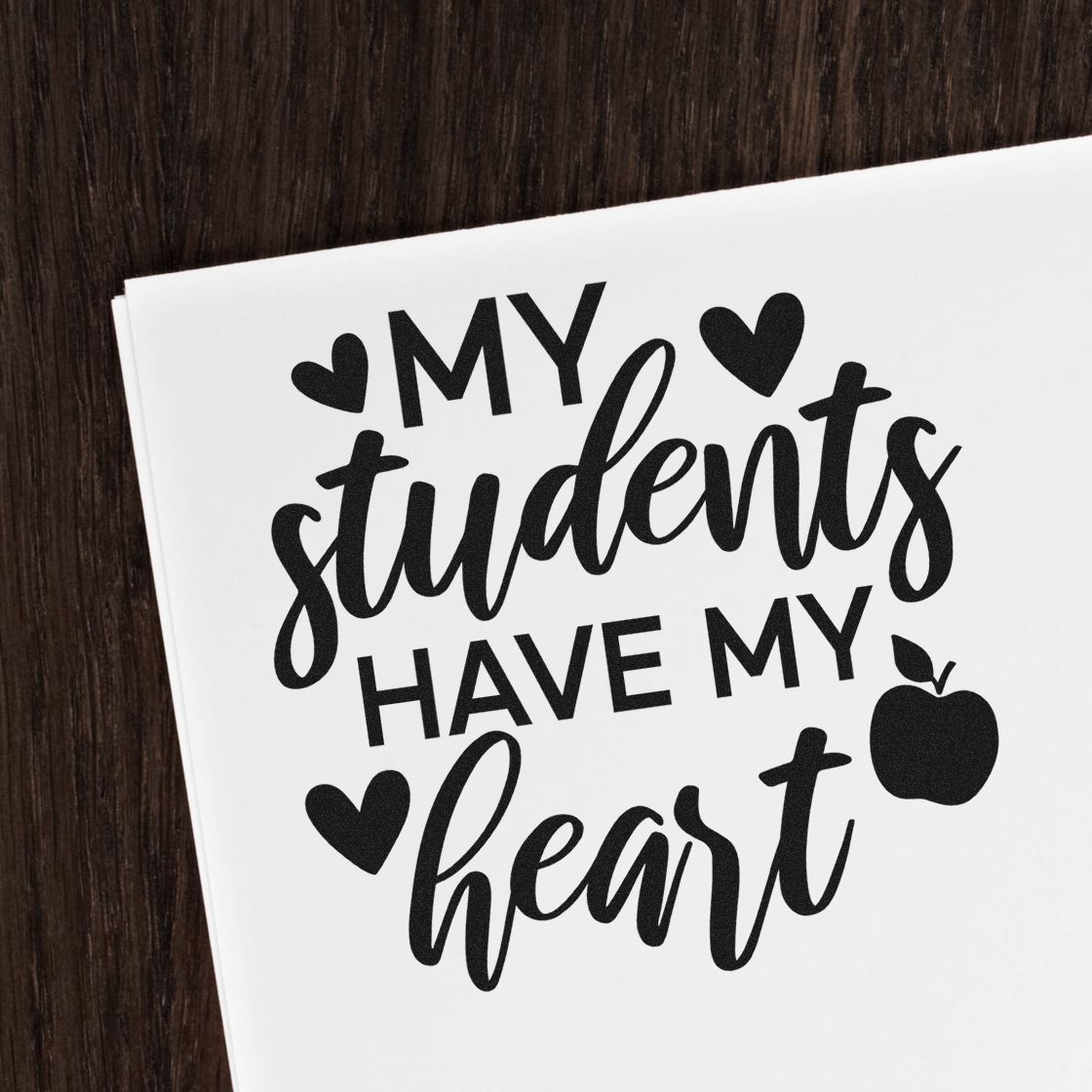 Students Have My Heart Apple Premium Wooden Stamp - Vintage Pro imprint stamped in black ink. "My Students Have My Heart" is surrounded by hearts and an apple.