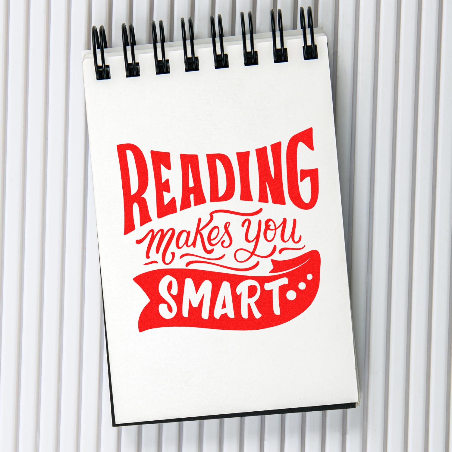 Reading makes you smart quote rubber stamp design on a spiral notebook, ideal for teachers, classrooms, and book lovers.