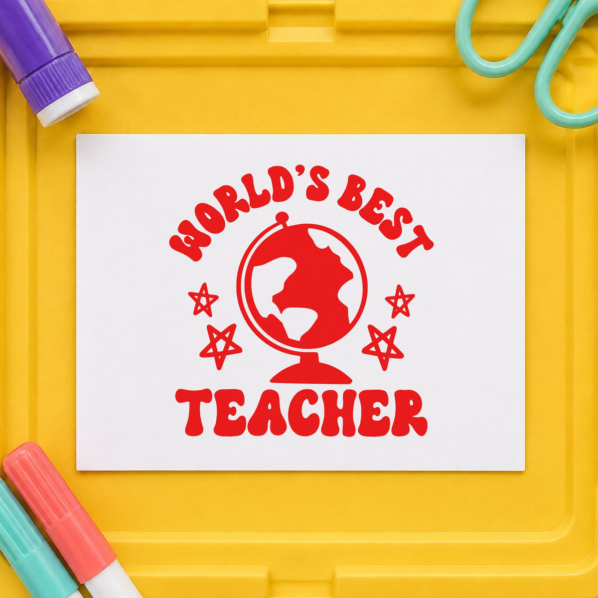 World's Best Teacher Globe rubber stamp shown in red ink, stamped for projects such as stargaze night notes.