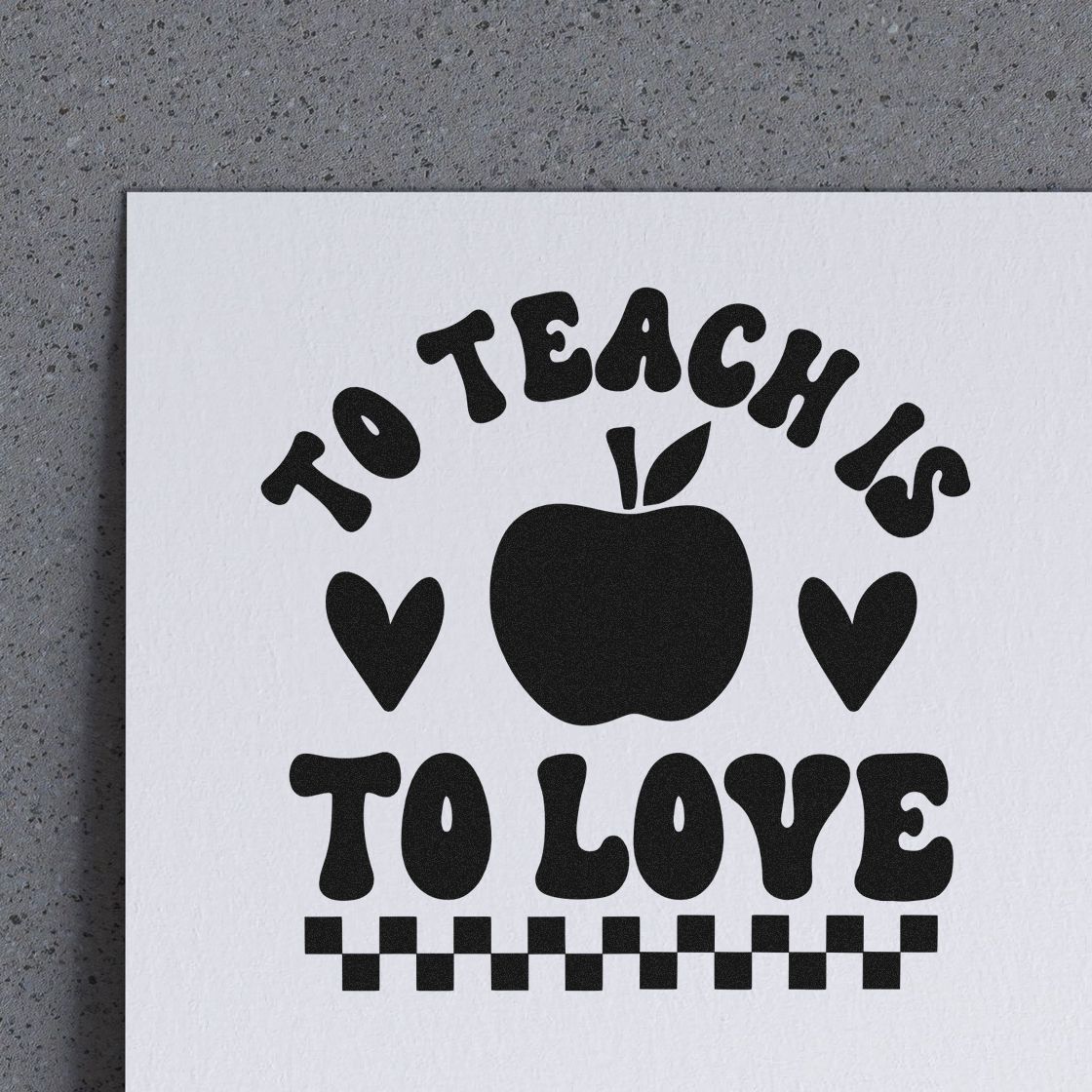 To Teach Is To Love Apple Premium Wooden Stamp - Vintage Pro imprint stamped in black ink. "To Teach Is to Love" surrounds an apple and two hearts above a checkerboard strip.